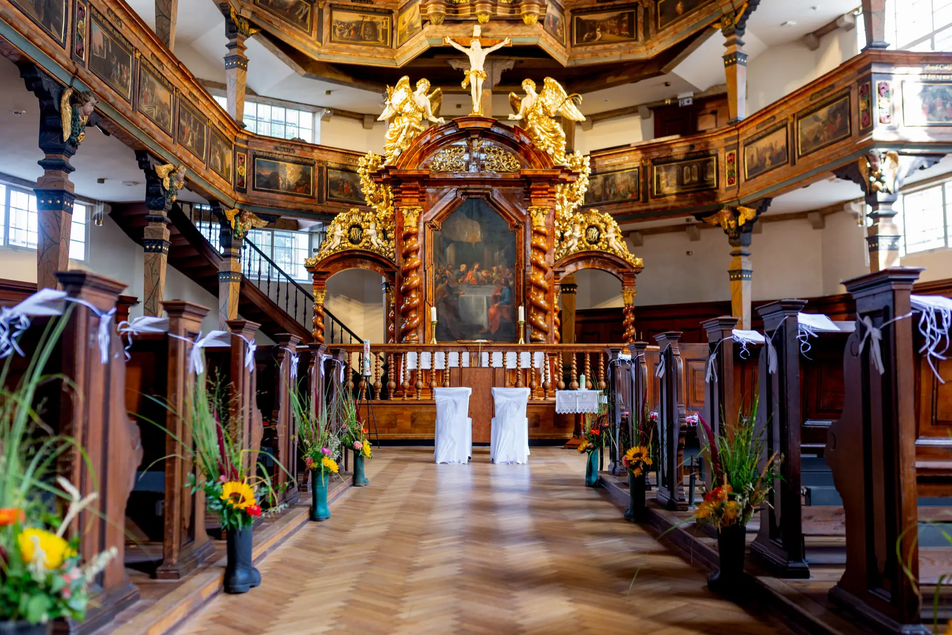 Kirchenschiff mit Altarbild, Blumendekoration und Brautpaar
