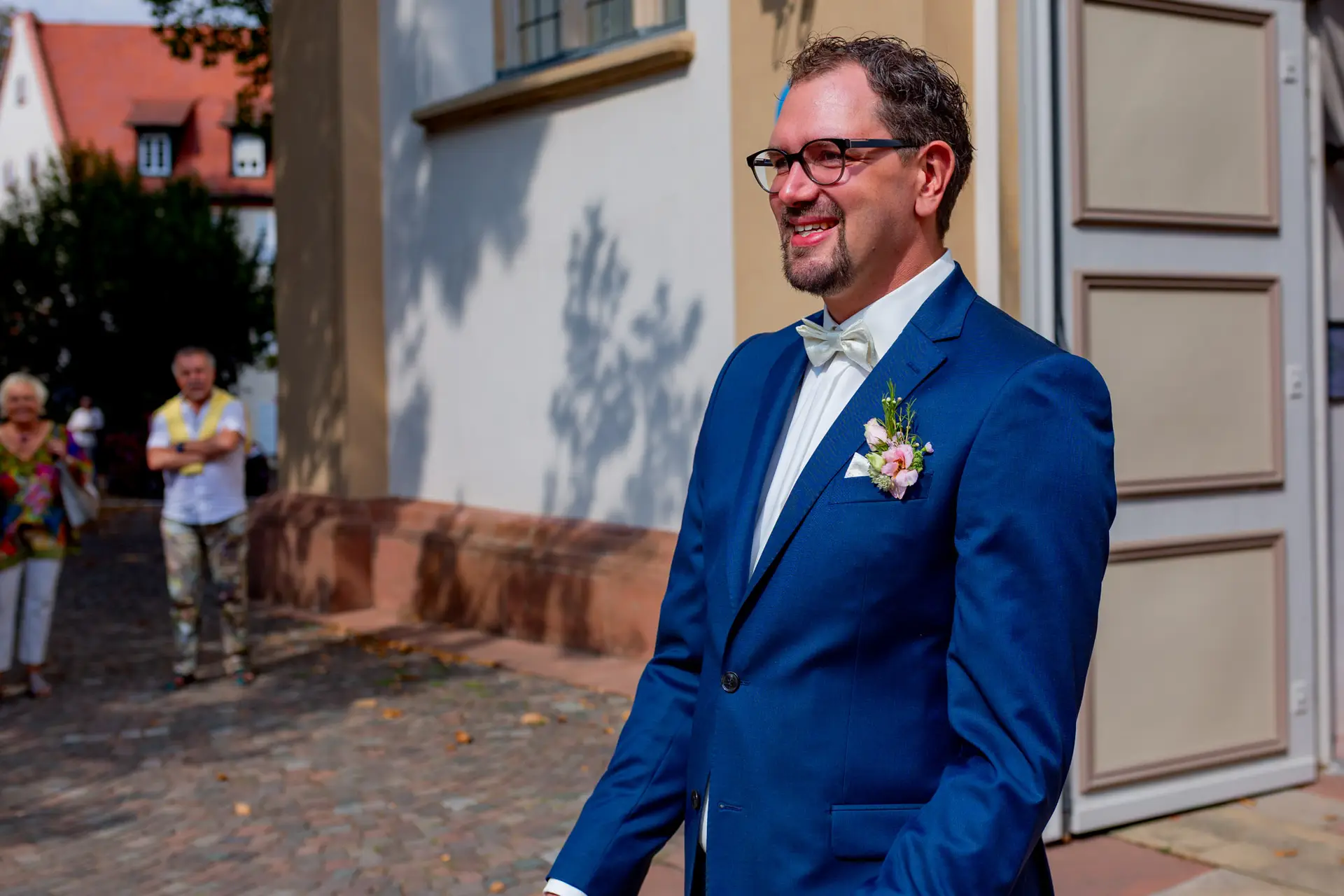 Schicker Bräutigam in Marineblau blickt erwartungsvoll auf die Hochzeit