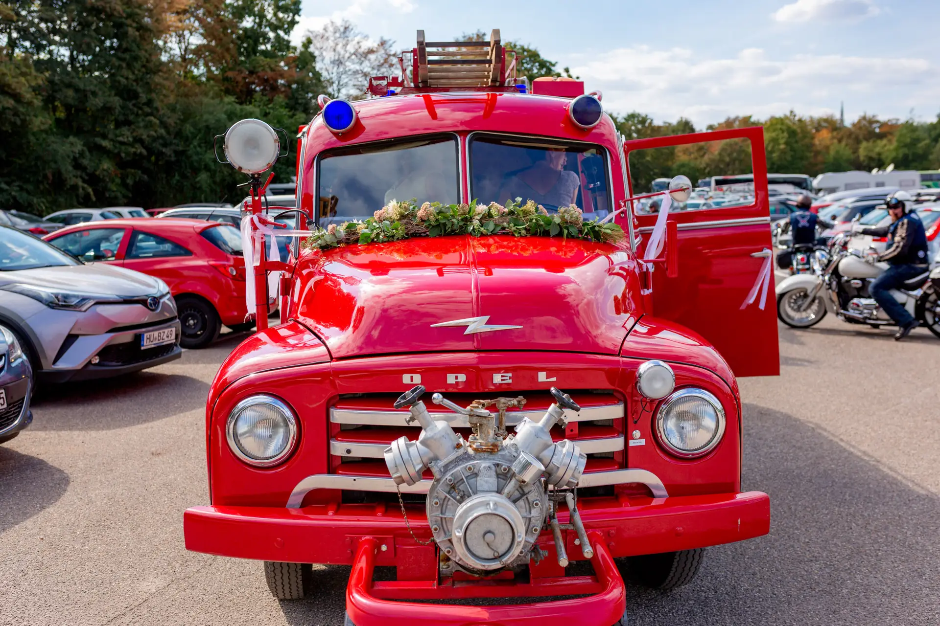 Rotes Feuerwehrauto mit Blumendekoration als besonderes Brautauto