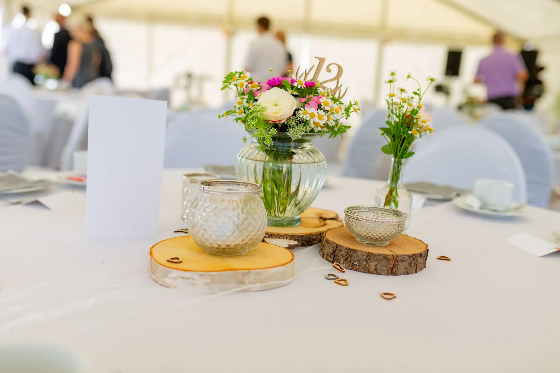Brautpaar-Tischdeko mit Blumenvasen und Holzscheiben im Festzelt Reilingen