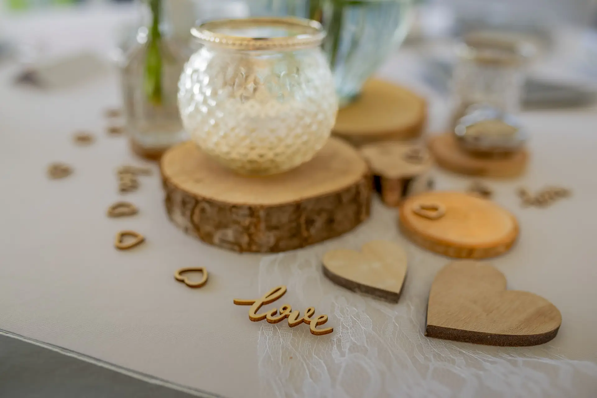 Herz aus Holz, Kerze und Blumen – romantische Tischdekoration zur Hochzeit