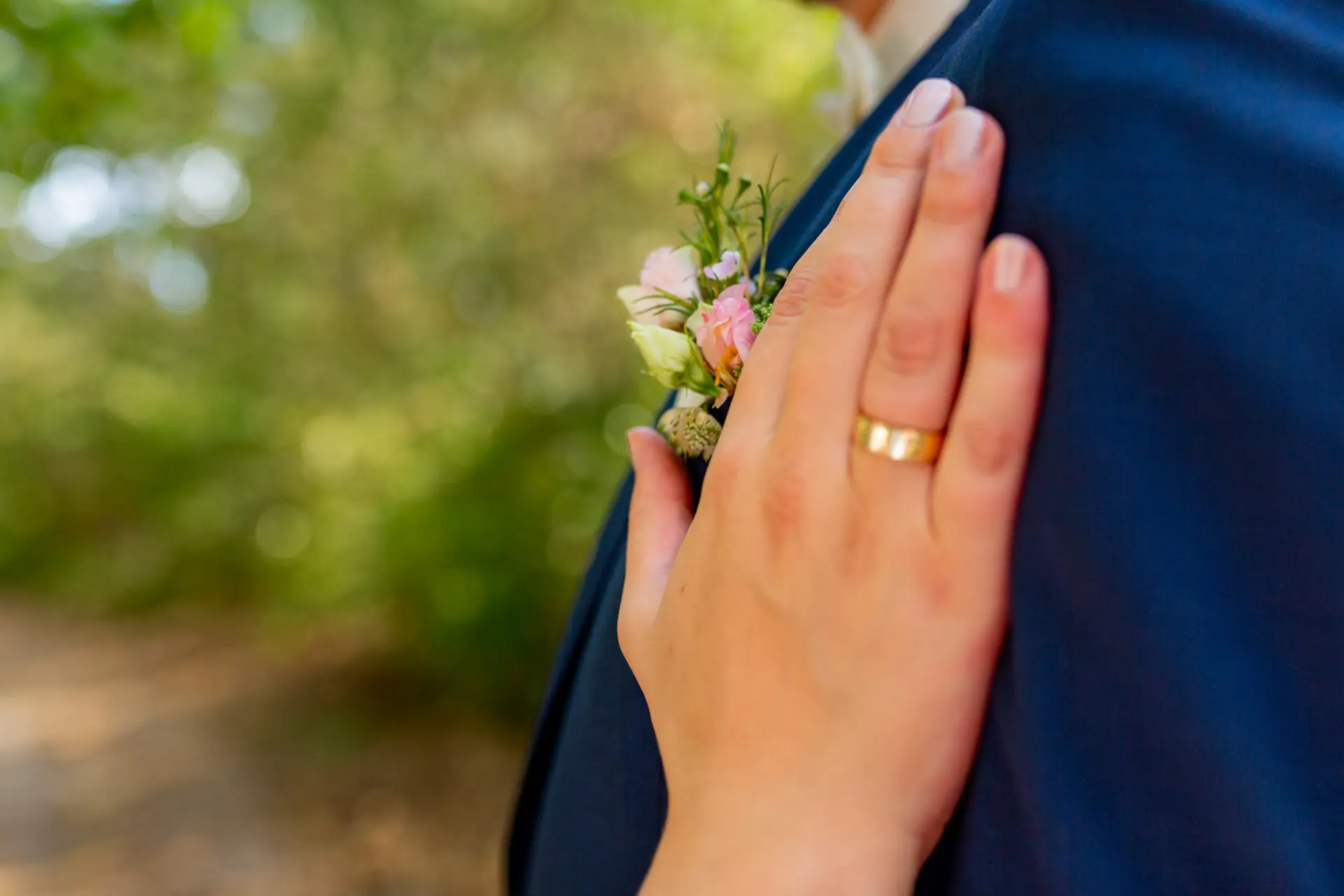 Braut hält Blumenstrauß beim romantischen Brautpaarshooting am See