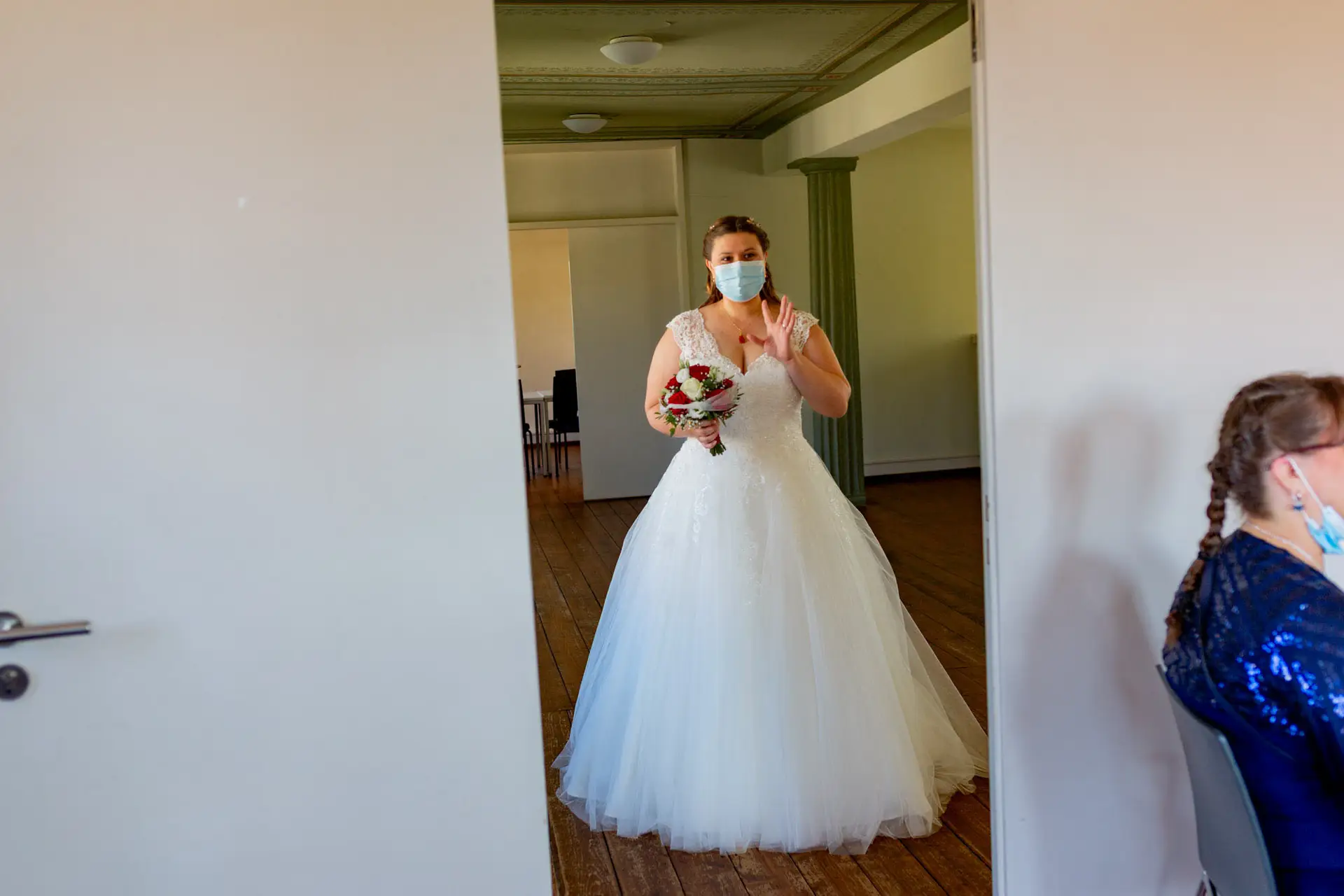 Braut betritt den Trausaal im Standesamt Feudenheim mit Brautstrauß aus roten Rosen