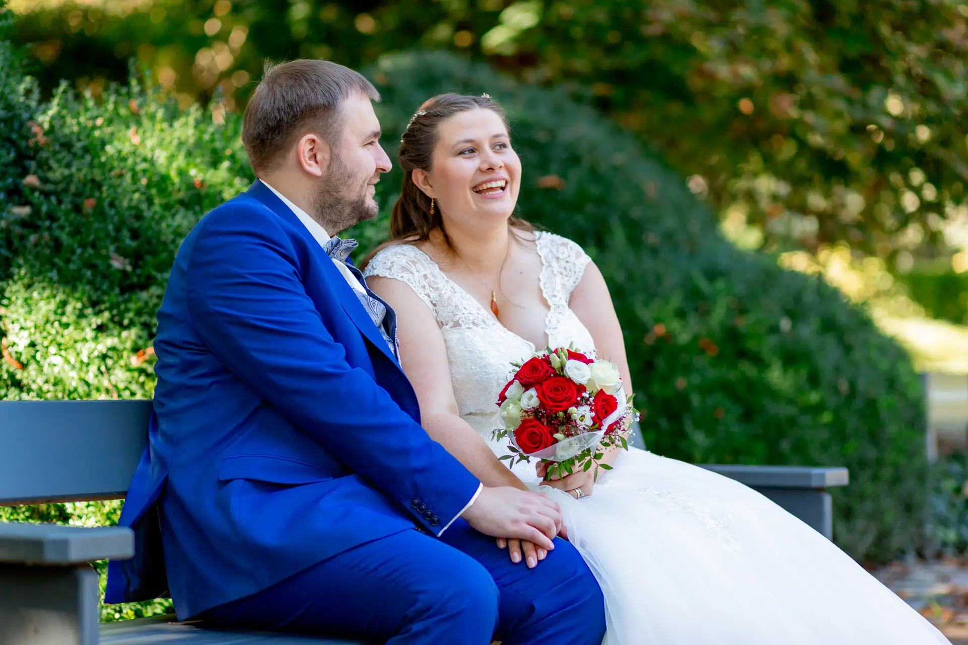 Brautpaar sitzt entspannt auf einer Parkbank im Luisenpark Mannheim