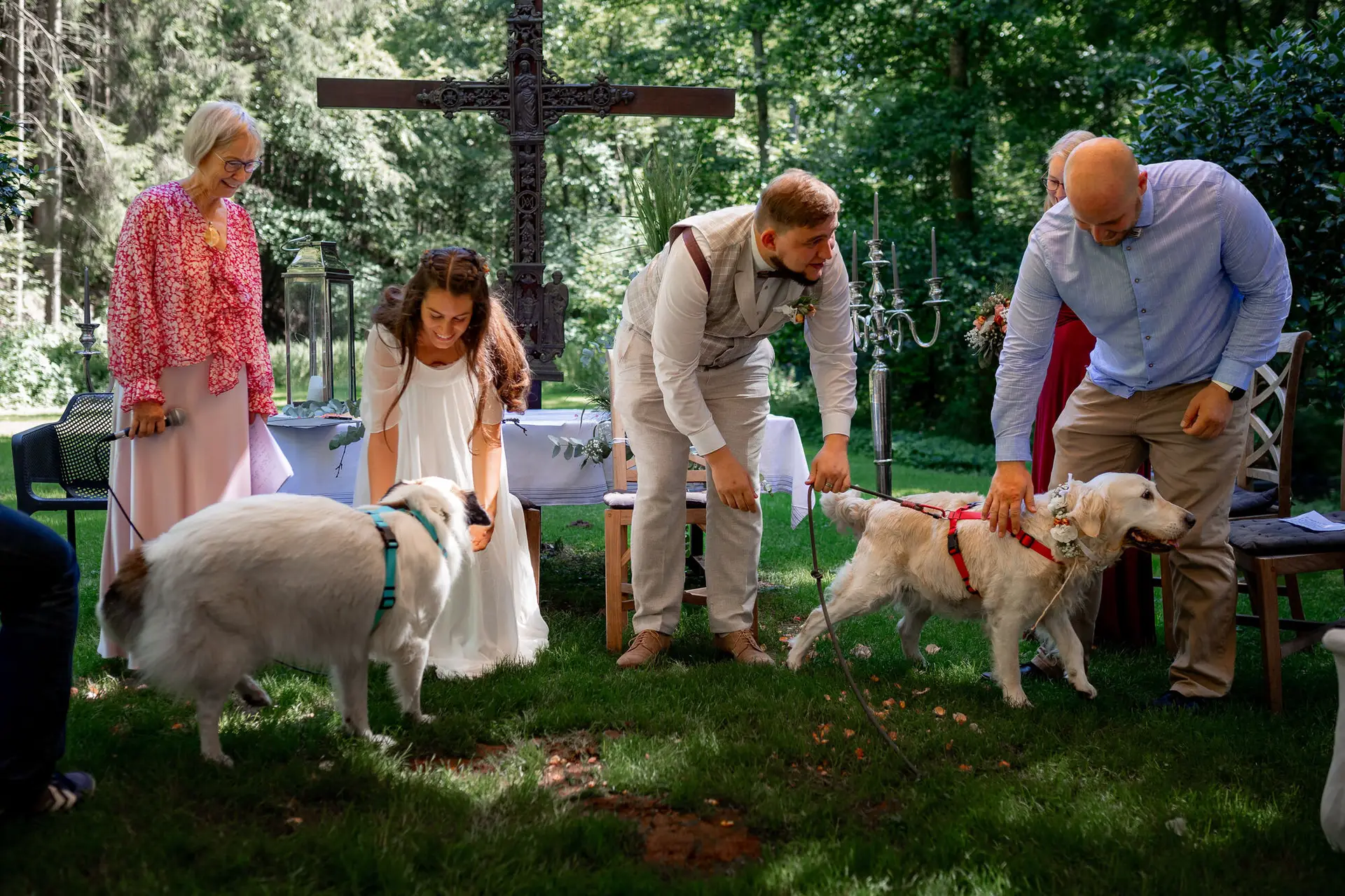 Brautpaar mit zwei weißen Golden Retrievern vor dem Holzkreuz – das Ja-Wort mit tierischer Begleitung
