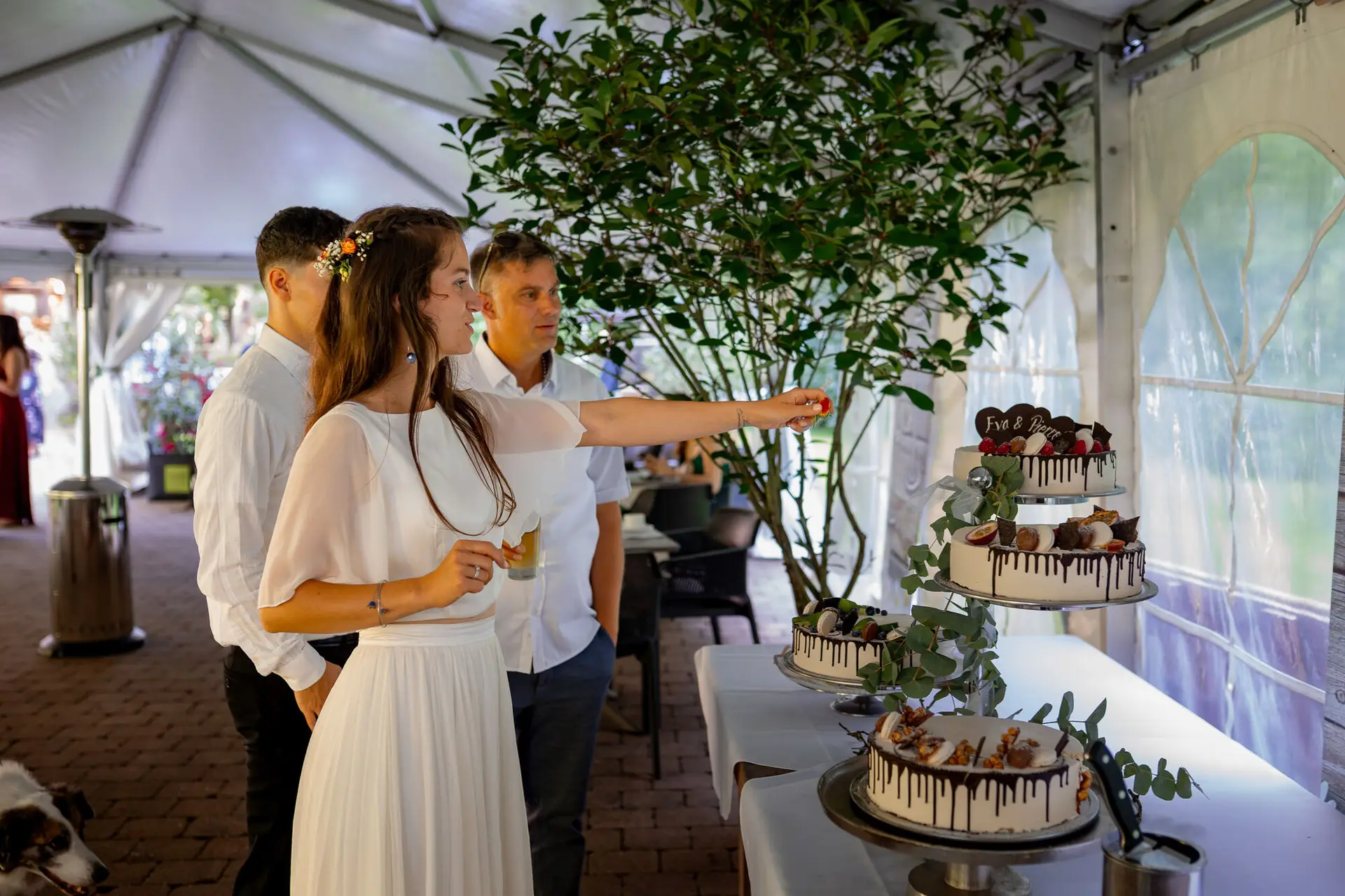 Brautpaar steht vor der mehrstöckigen Hochzeitstorte bereit zum Anschneiden