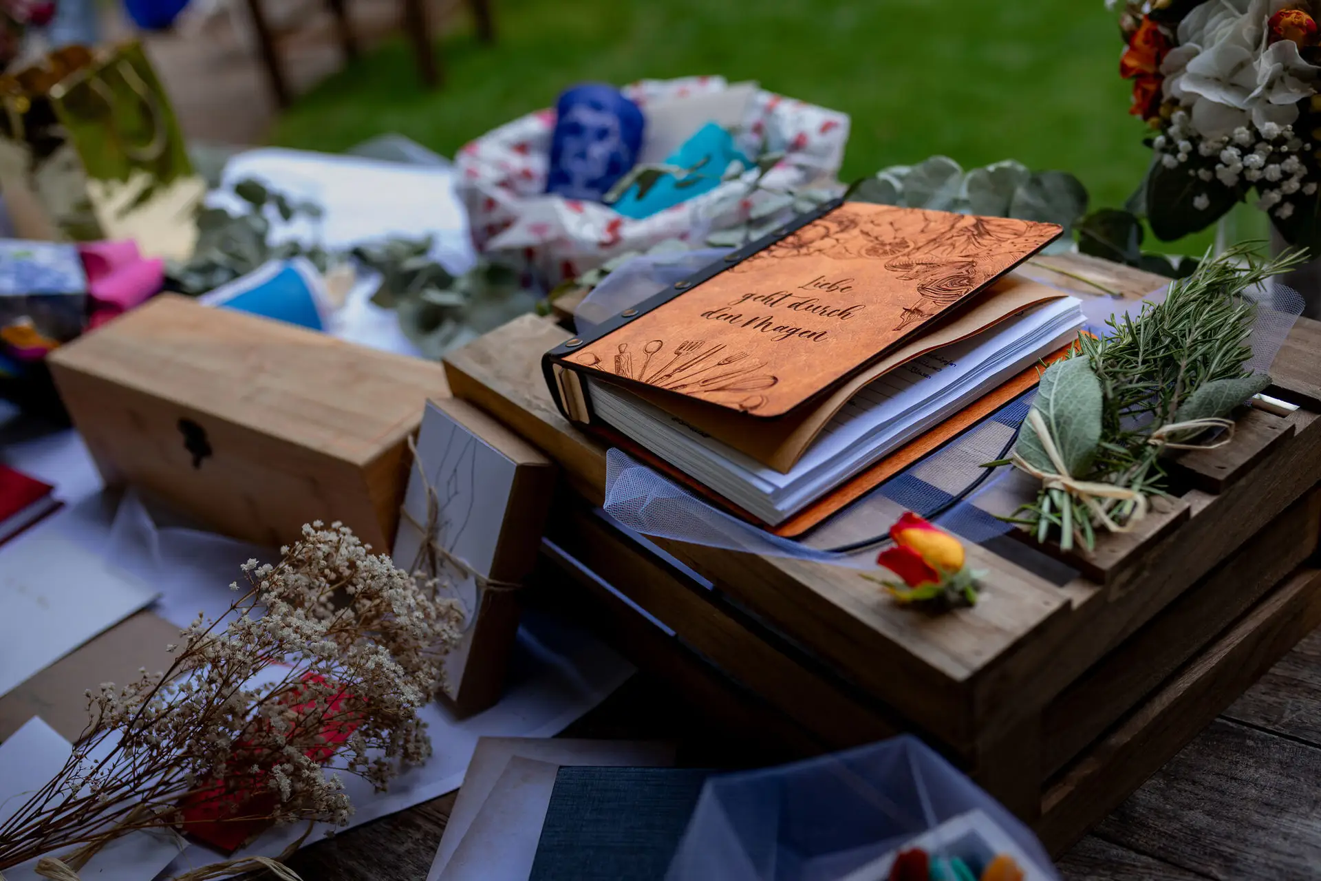 Detailaufnahme der Hochzeitsdekoration – Notizbuch, Scheren und Blumen auf dem Rasen als Deko-Element