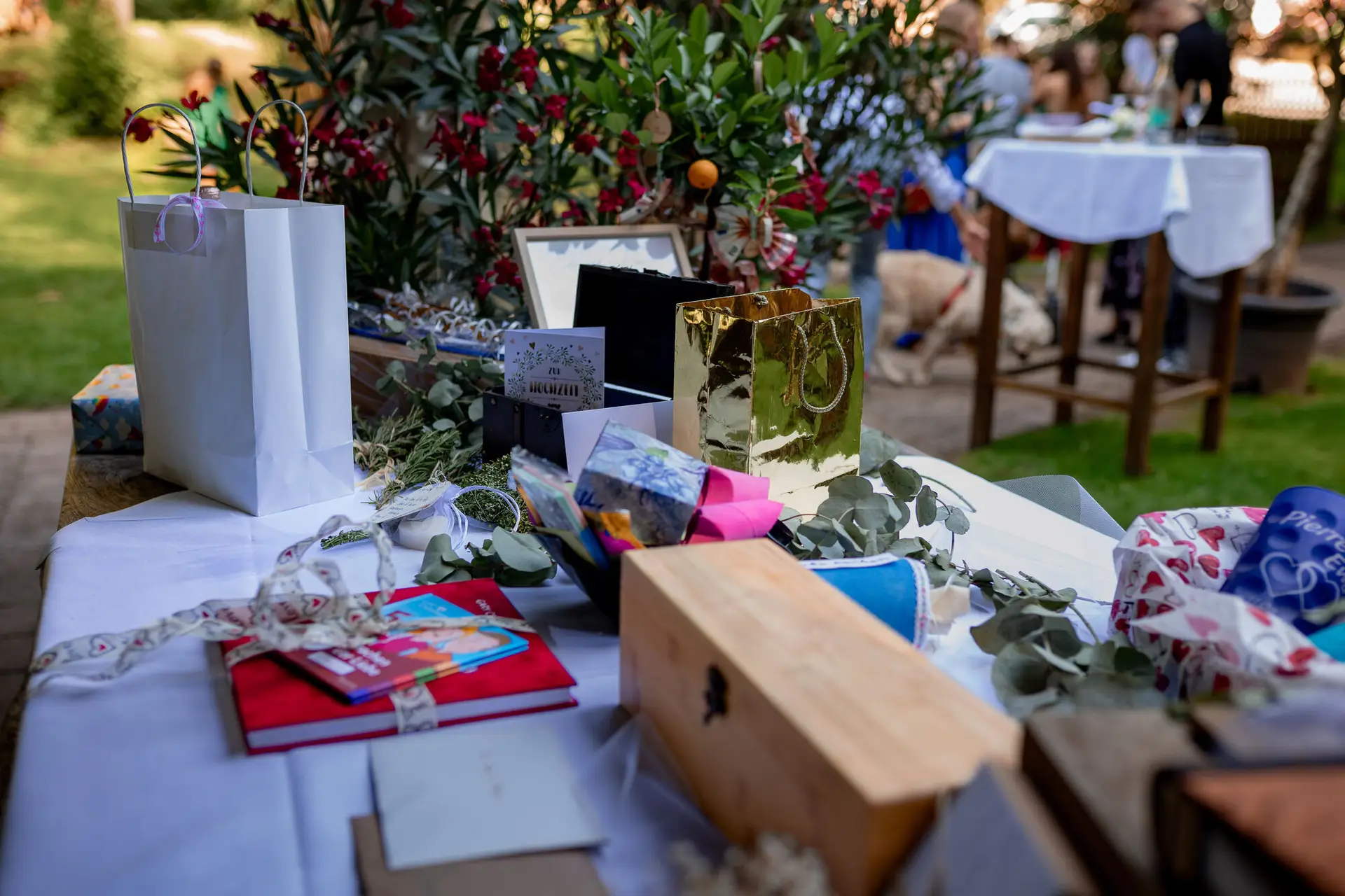 Geschenke und goldenes Fotoalbum auf dem Empfangstisch – liebevoll arrangiert