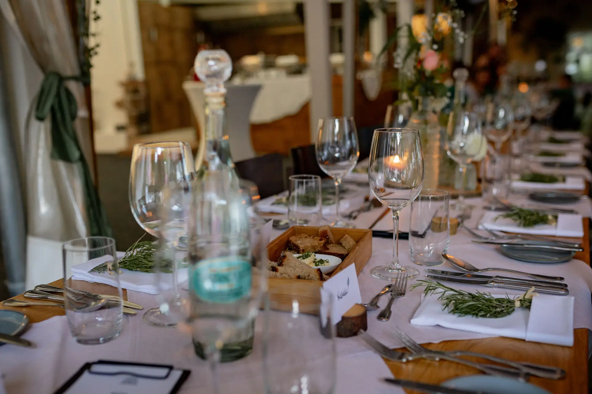 Elegant gedeckter Tisch für das Hochzeitsabendessen mit Kristallgläsern, Besteck und Blumenarrangements