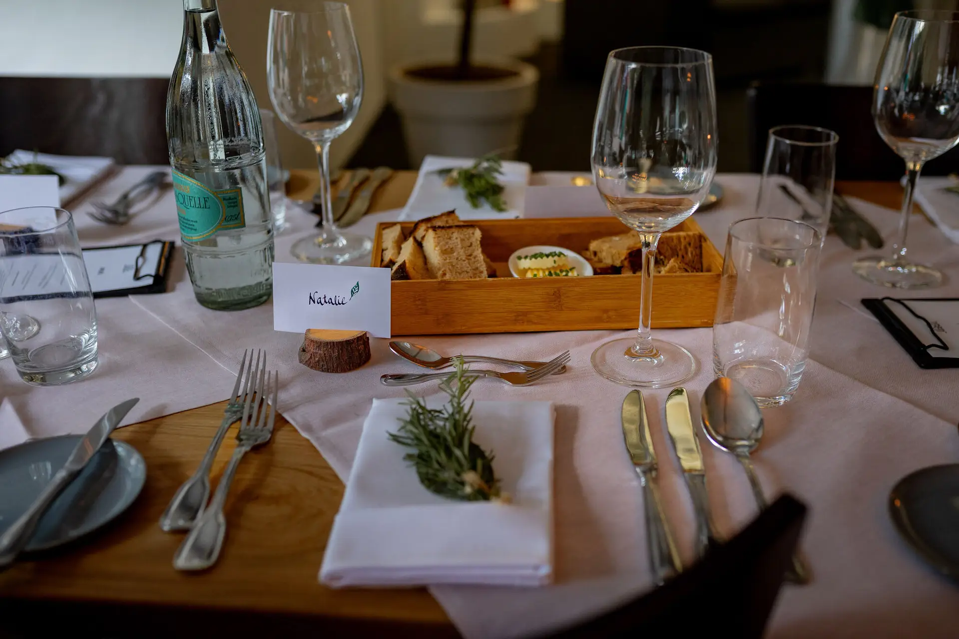 Tischdetail mit rosa Tischläufer, Namensschildern, Gläsern und Besteck