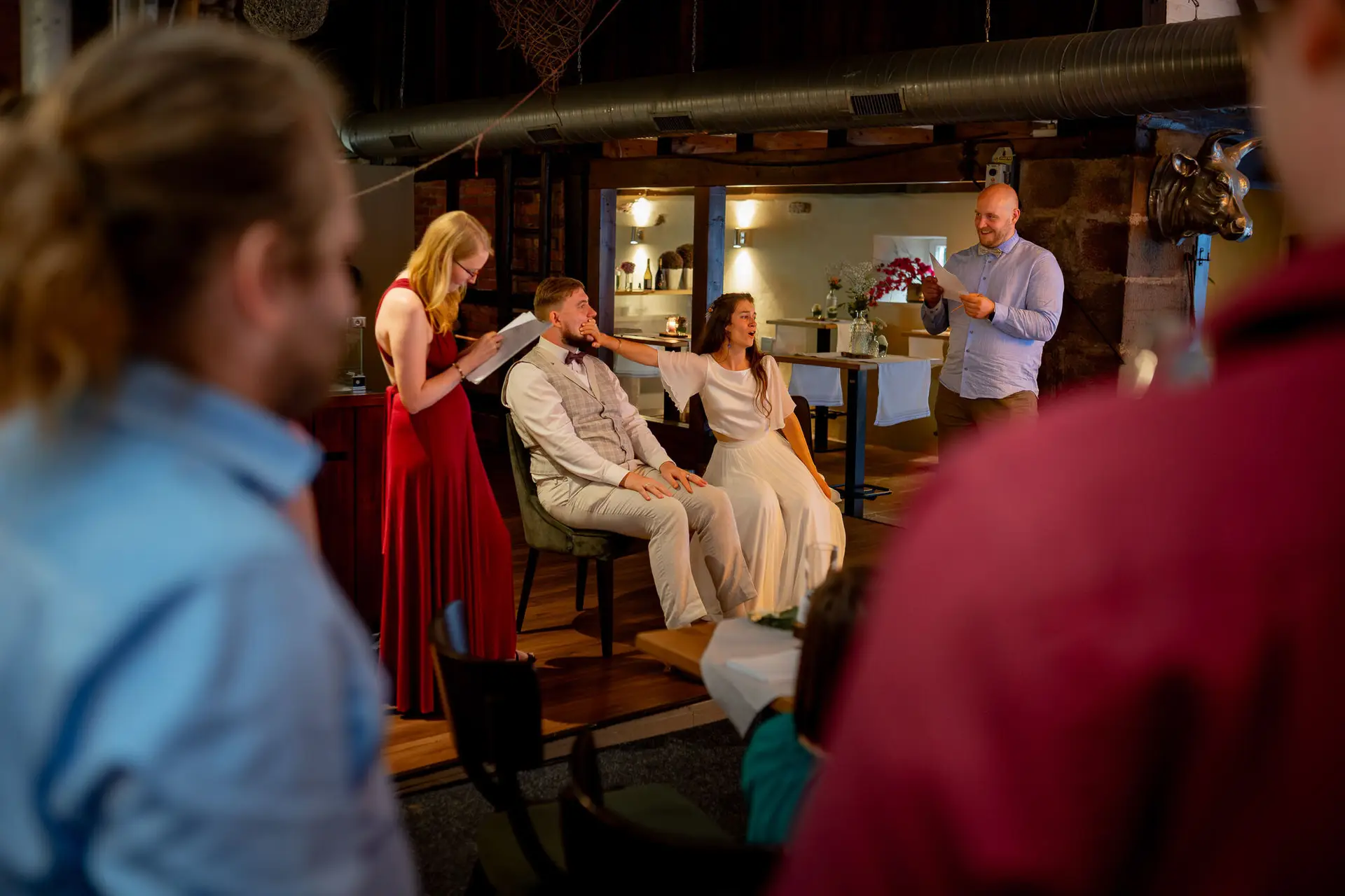 Bräutigam trägt die Braut lachend auf dem Rücken beim ausgelassenen Hochzeitsabend