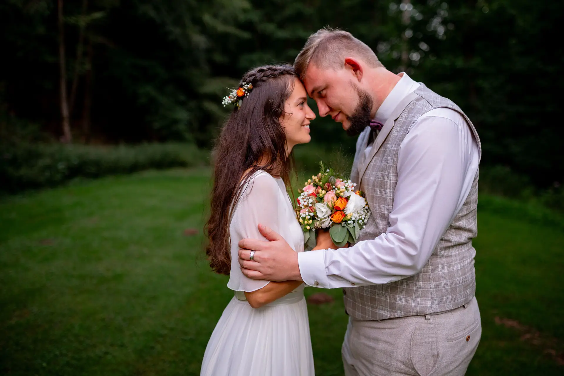 Brautpaar im abendlichen Elztal-Wald, Bräutigam hält Braut mit Blumenkrone liebevoll