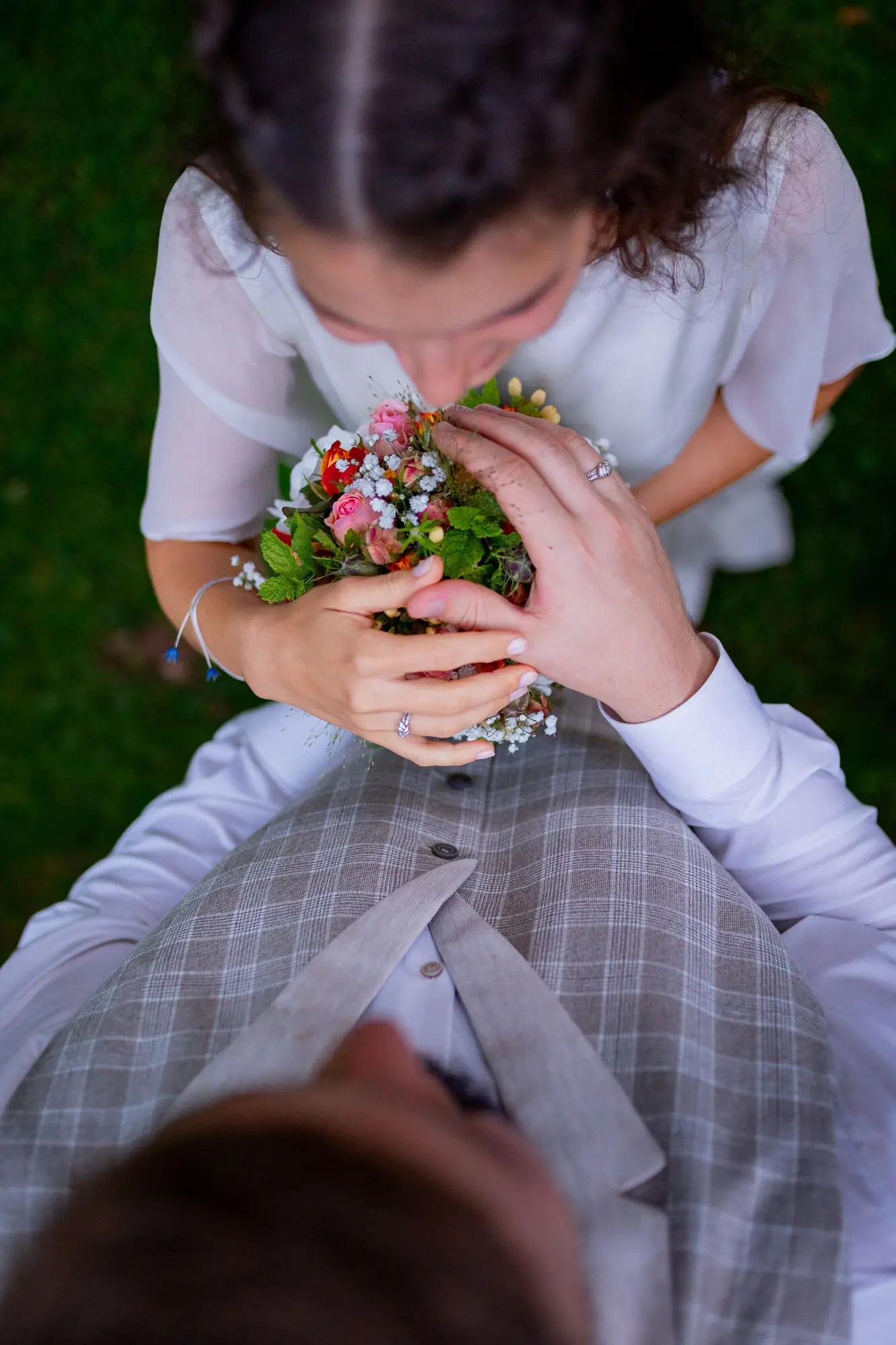 Brautpaar sitzt auf der Wiese mit Blumengirland beim goldenen Abendlicht des Elztals