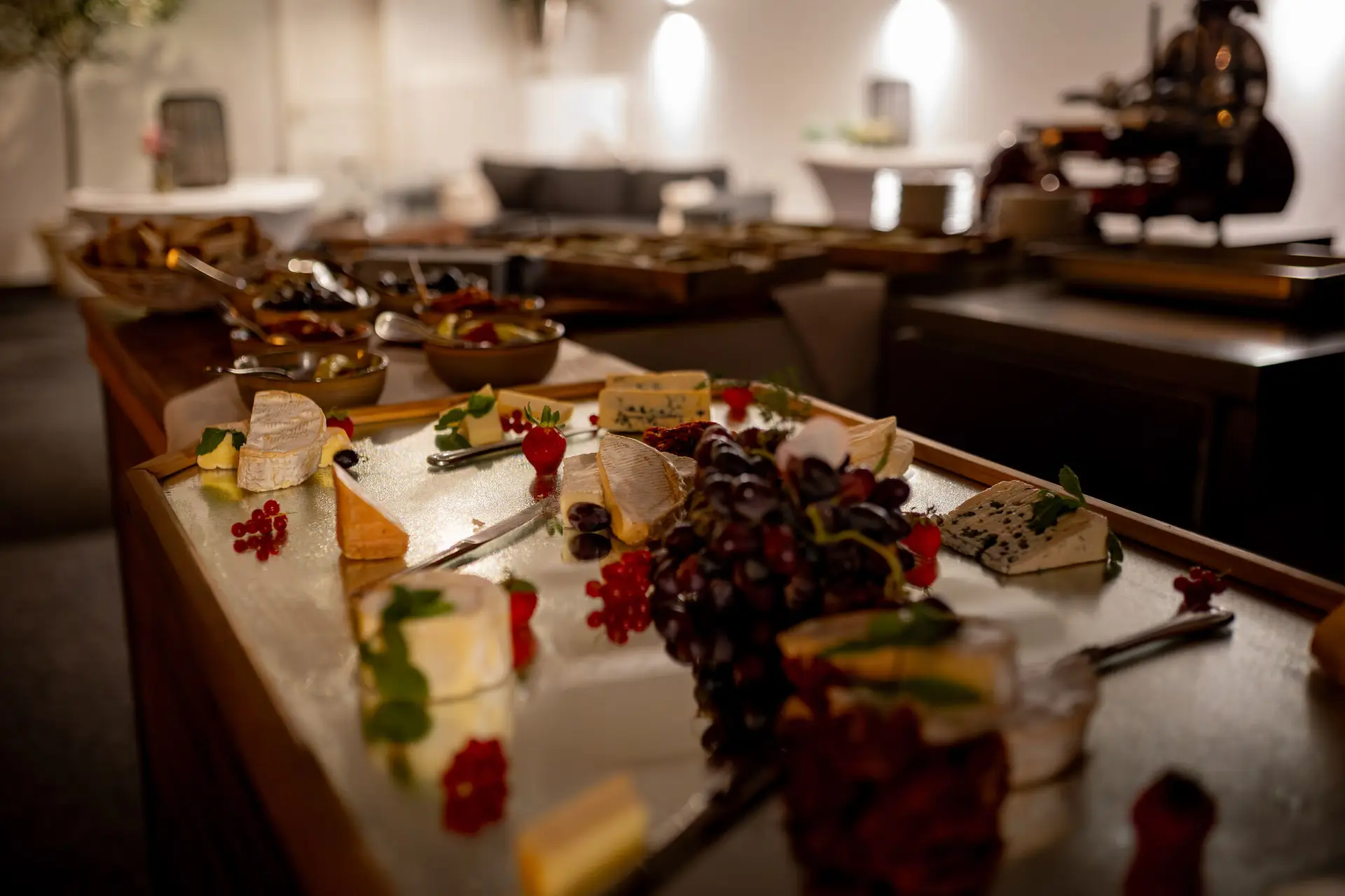 Abend-Buffet mit Käse, Trauben und Beeren auf elegantem Tisch für die späten Gäste