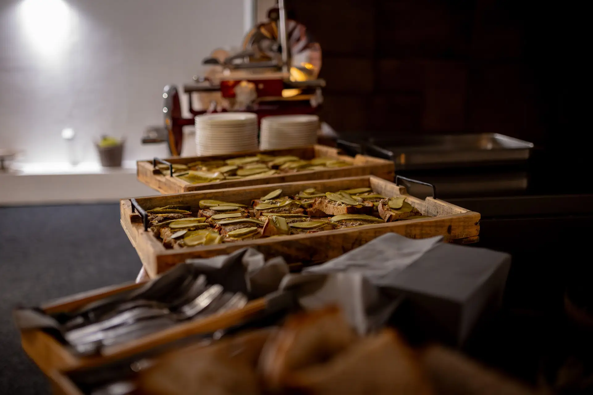 Rustikales Nacht-Buffet mit Wurst und eingelegten Gurken auf Holzservierplatten