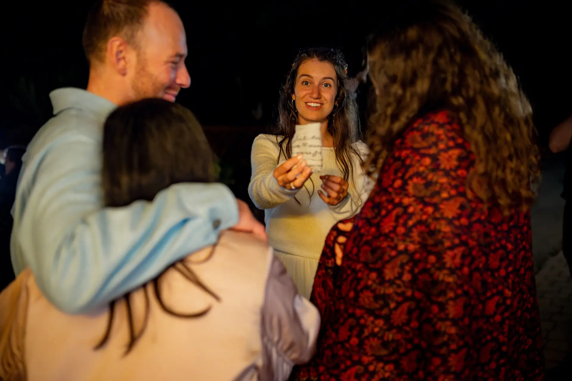 Frau hält Zettel und tanzt beim Hochzeitsspiel – ausgelassene Late-Night-Stimmung