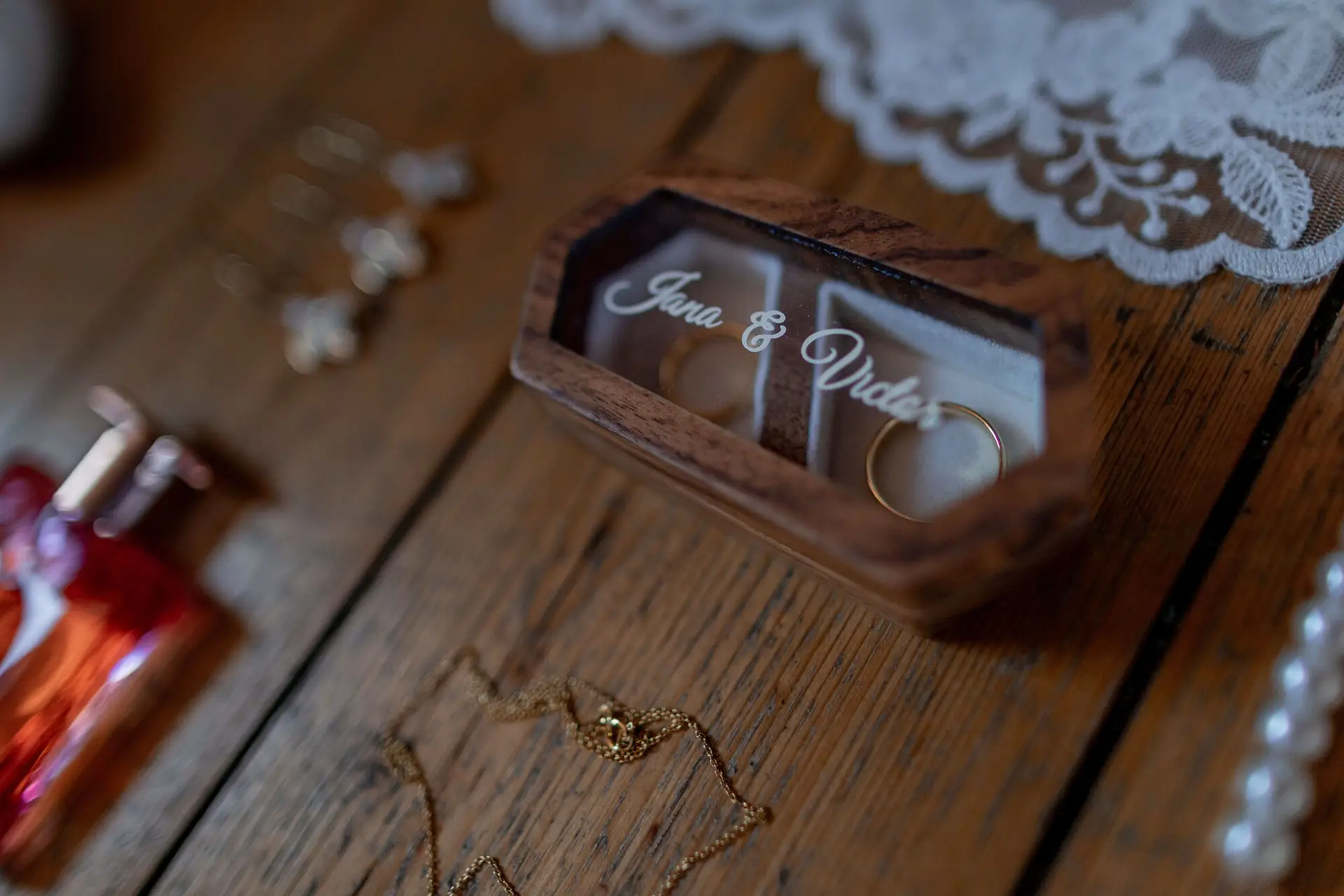 Detailansicht der Ringbox mit goldenen Schmuckketten auf Holzuntergrund