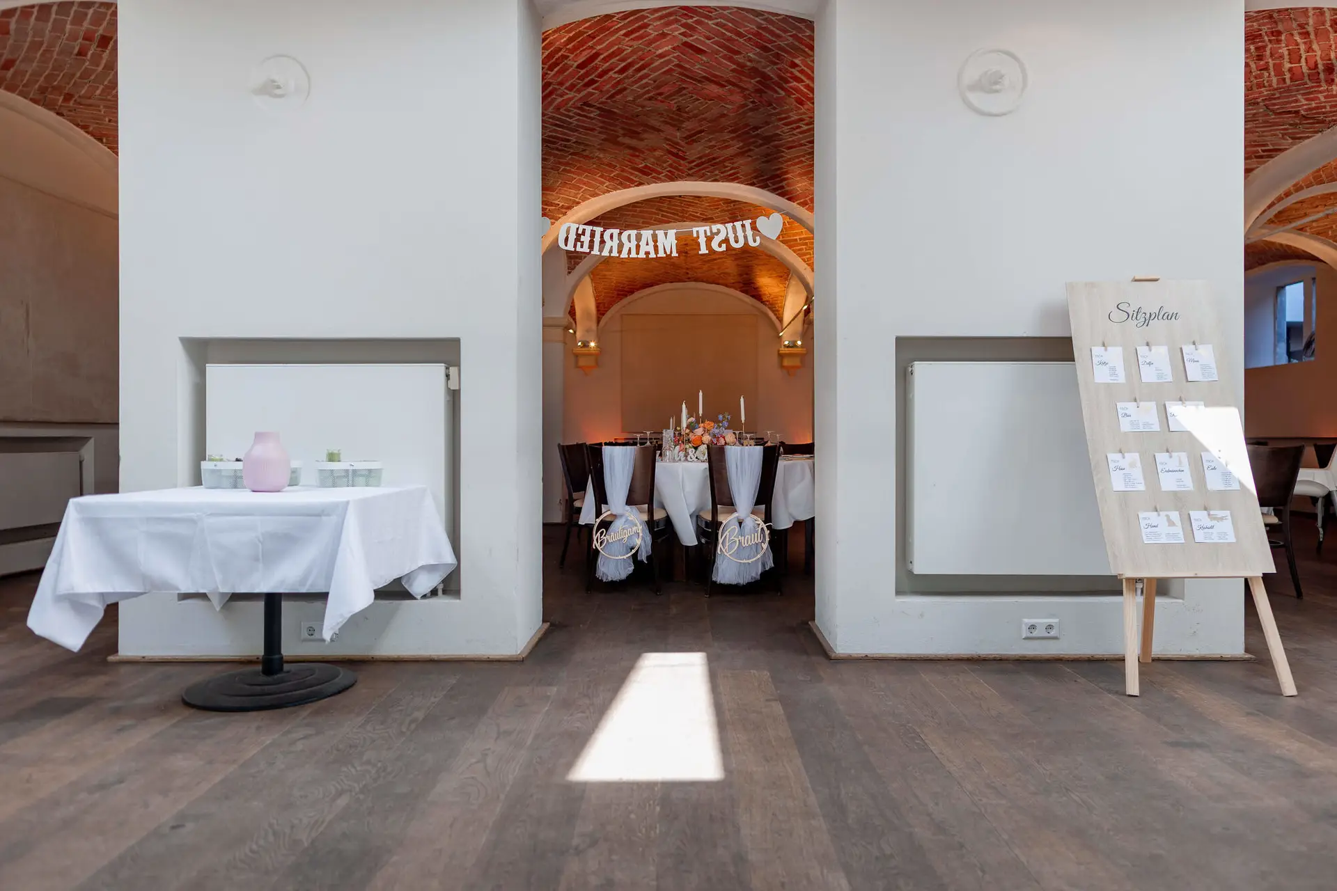 Festsaal-Eingang mit Just Married Schriftzug und Blick auf Hochzeitstafel