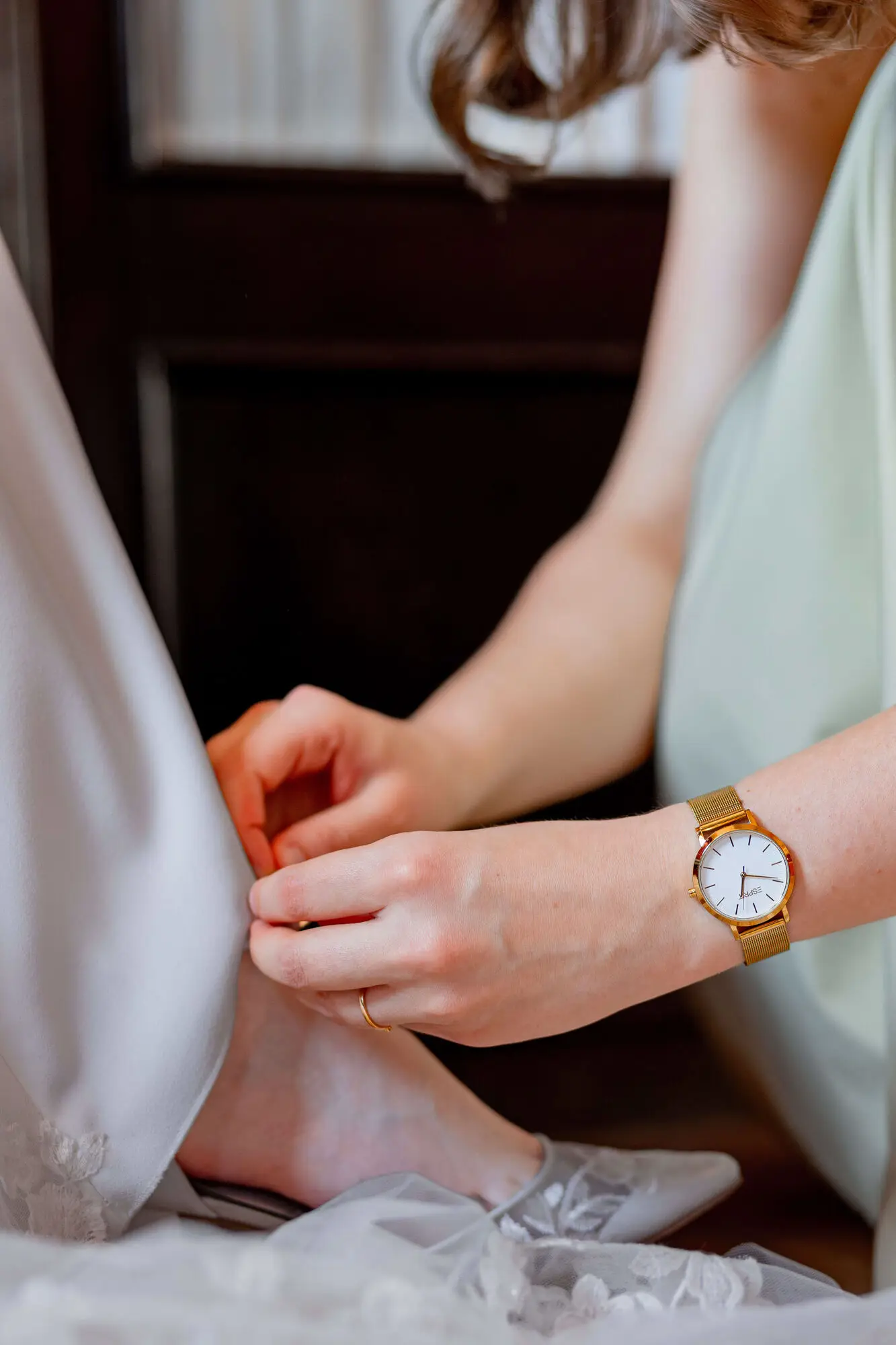 Brautpaar sitzt romantisch auf weißen Stühlen unter farbenfroh geschmücktem Blumenbogen im Weinberg Bad Dürkheim