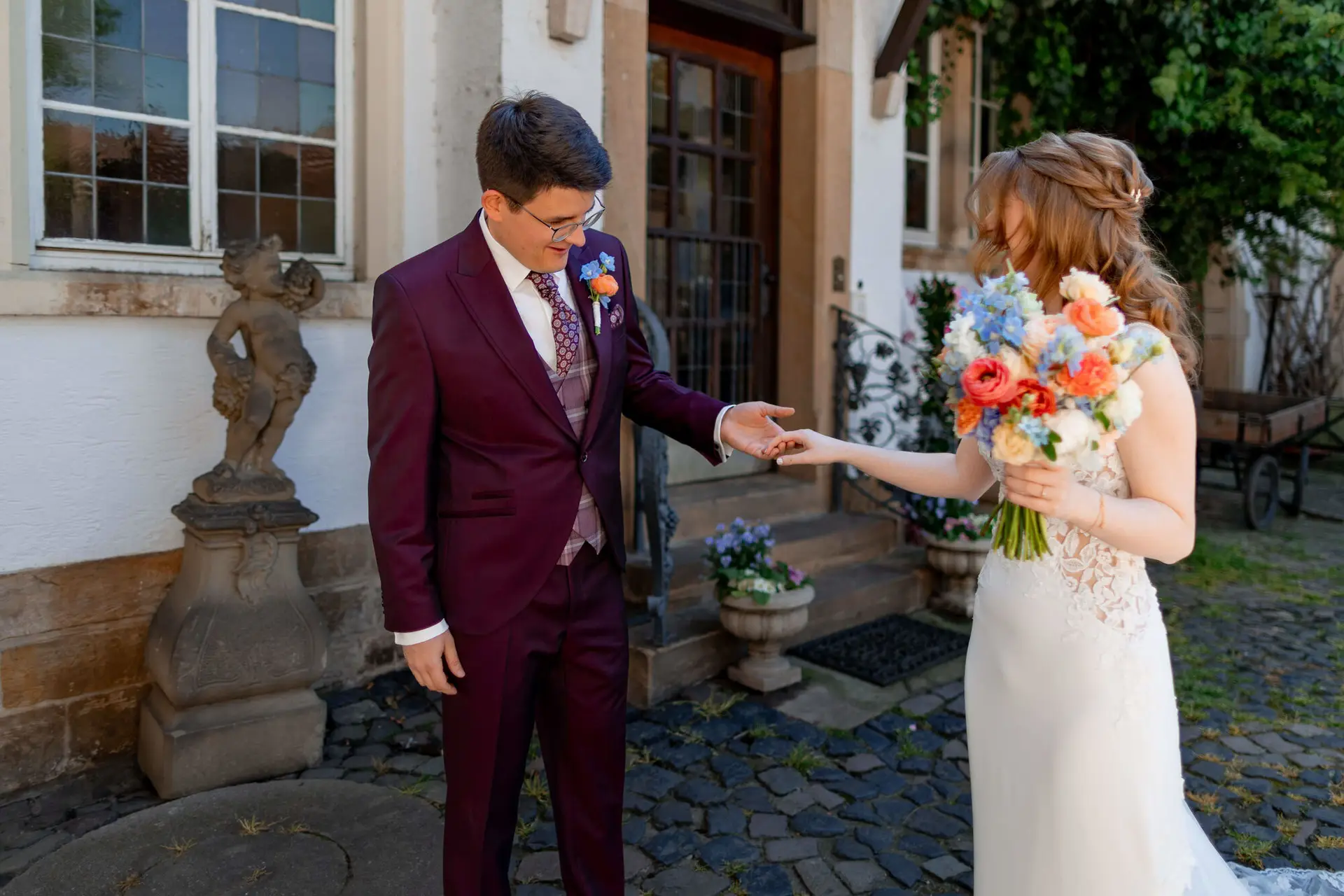 Emotionaler First Look Moment mit Brautpaar beim Händereichen im Innenhof