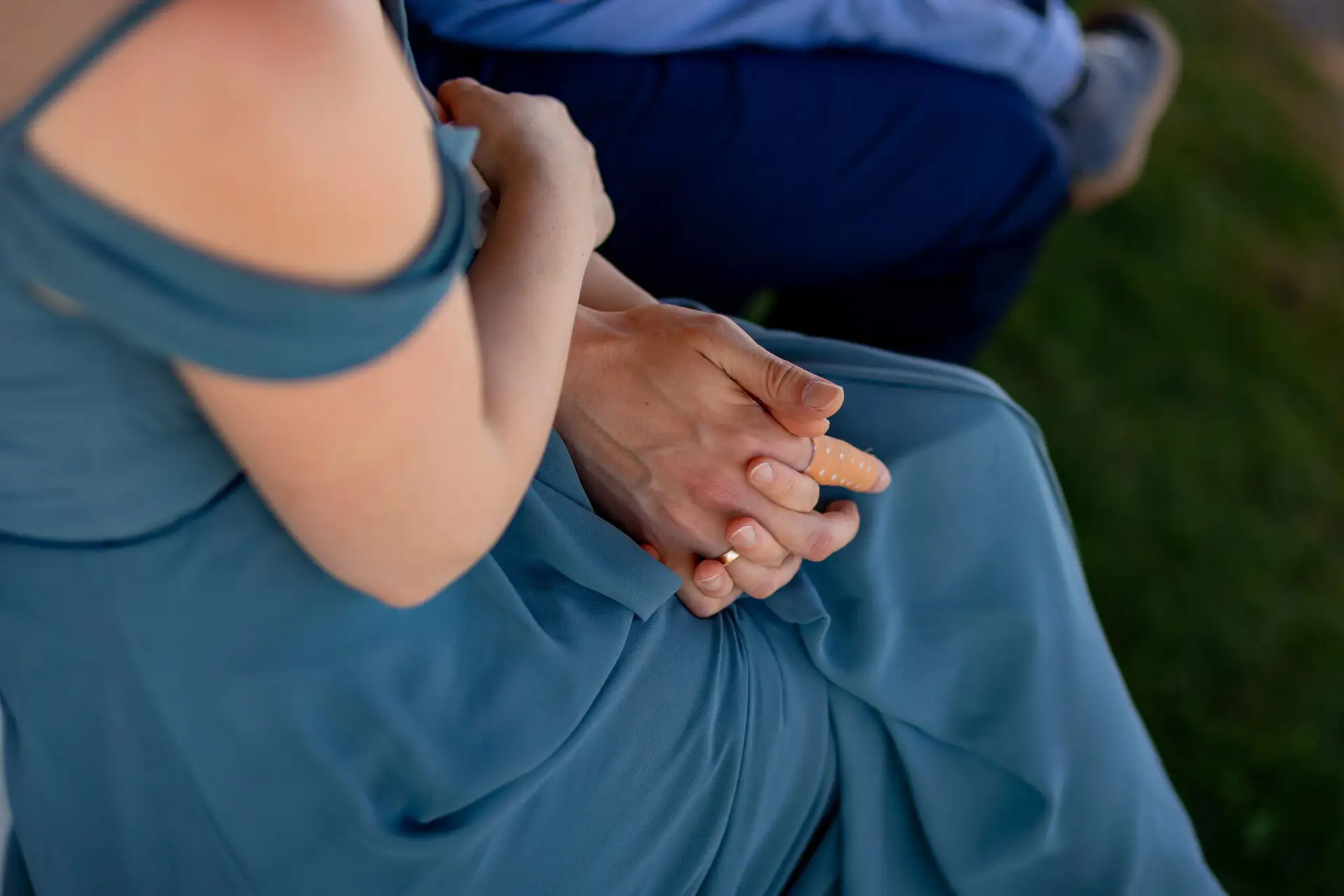 Brautpaar spaziert Hand in Hand durch blühenden Rosenbogen im Gutspark