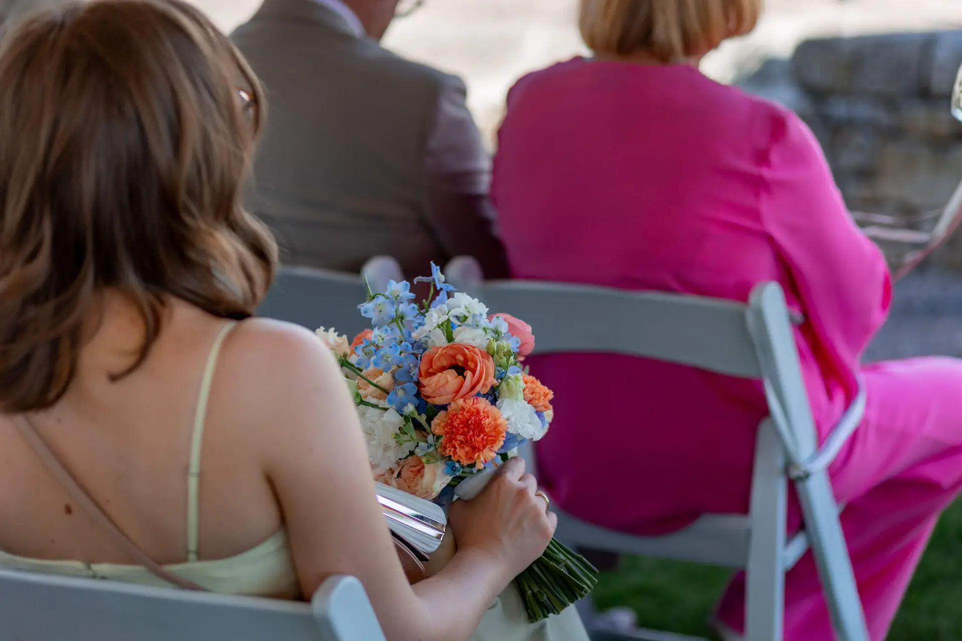Brautpaar stößt mit Sektgläsern im grünen Garten des Weinguts an