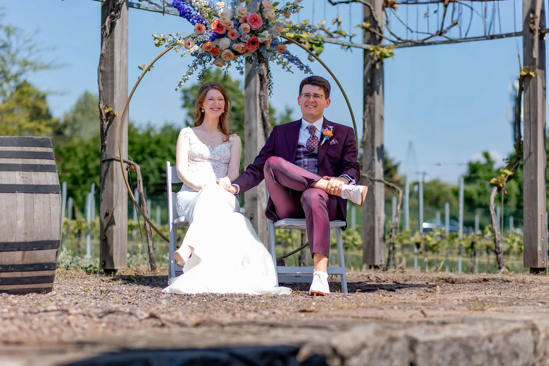 Brautpaar im eleganten weißen Gartenpavillon mit geöffneten Fenstertüren beim Hochzeitsshooting