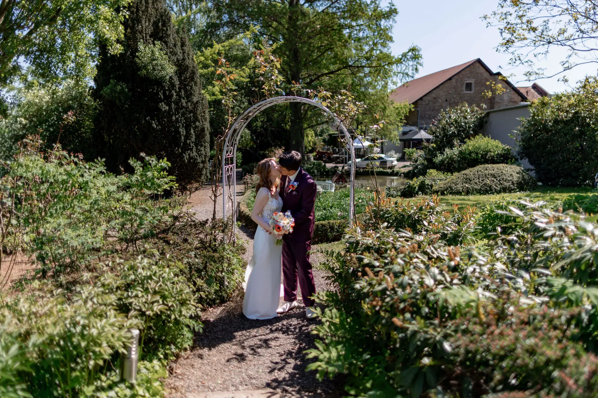 Romantische Nahaufnahme der Hände des Brautpaars mit buntem Brautstrauß