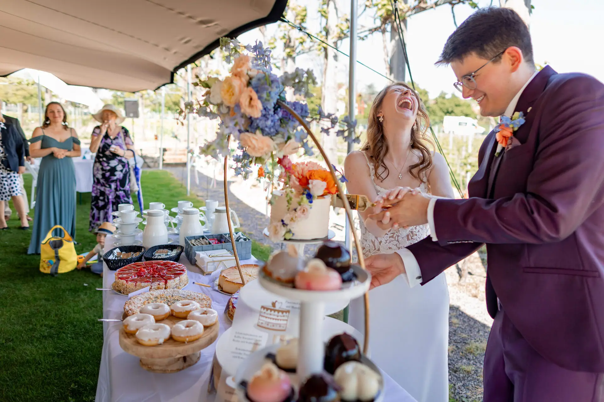 Braut und Trauzeugin lachen gemeinsam im Weinberg nach der Zeremonie