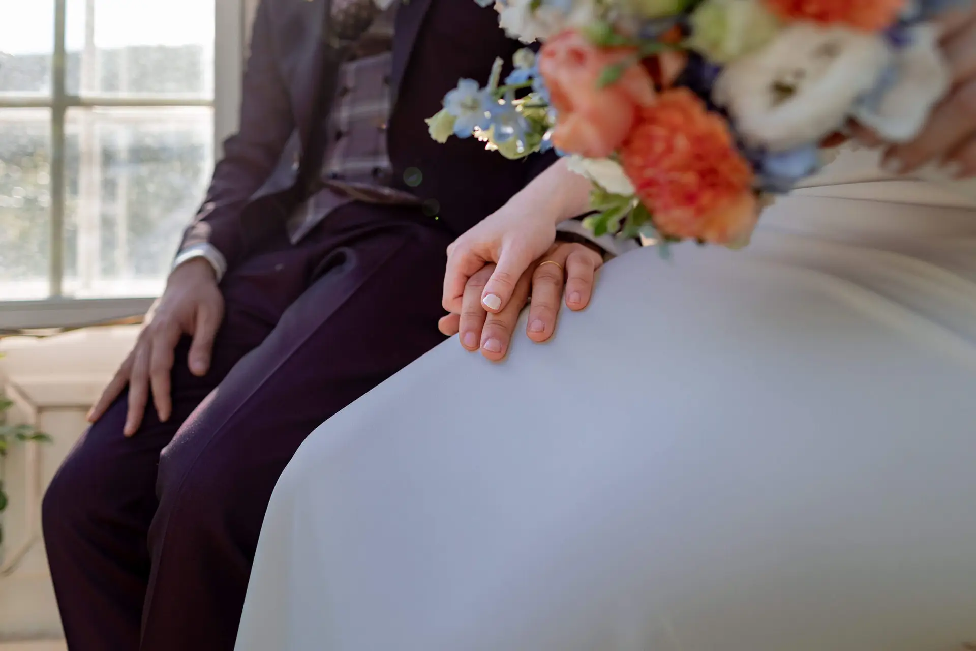 Nahaufnahme verschränkter Hände des Paares im warmen Sonnenlicht