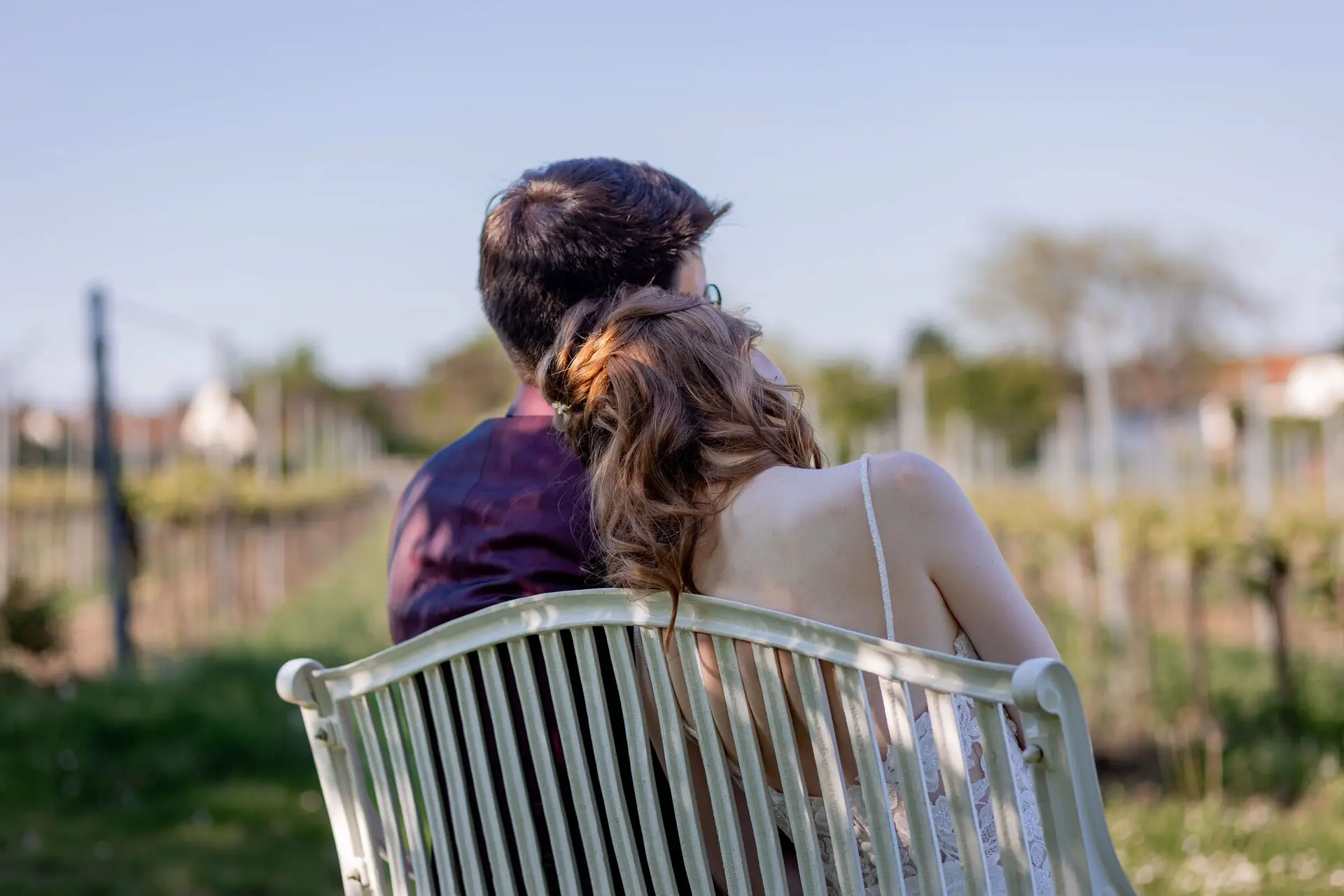 Brautpaar lehnt sich romantisch aneinander vor malerischer Weinberg-Kulisse
