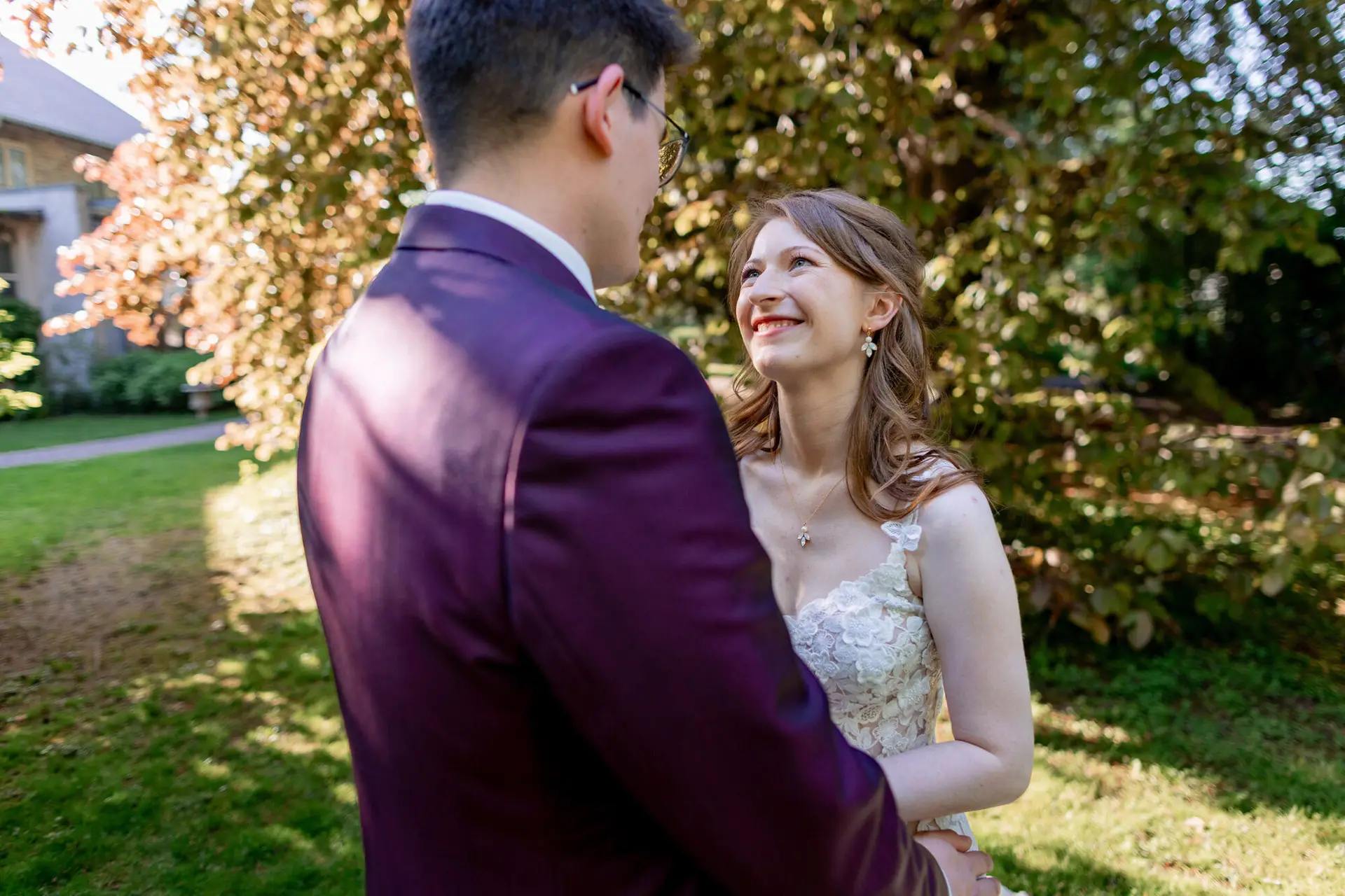 Braut blickt verliebt zum Bräutigam im grünen Garten des Weinguts