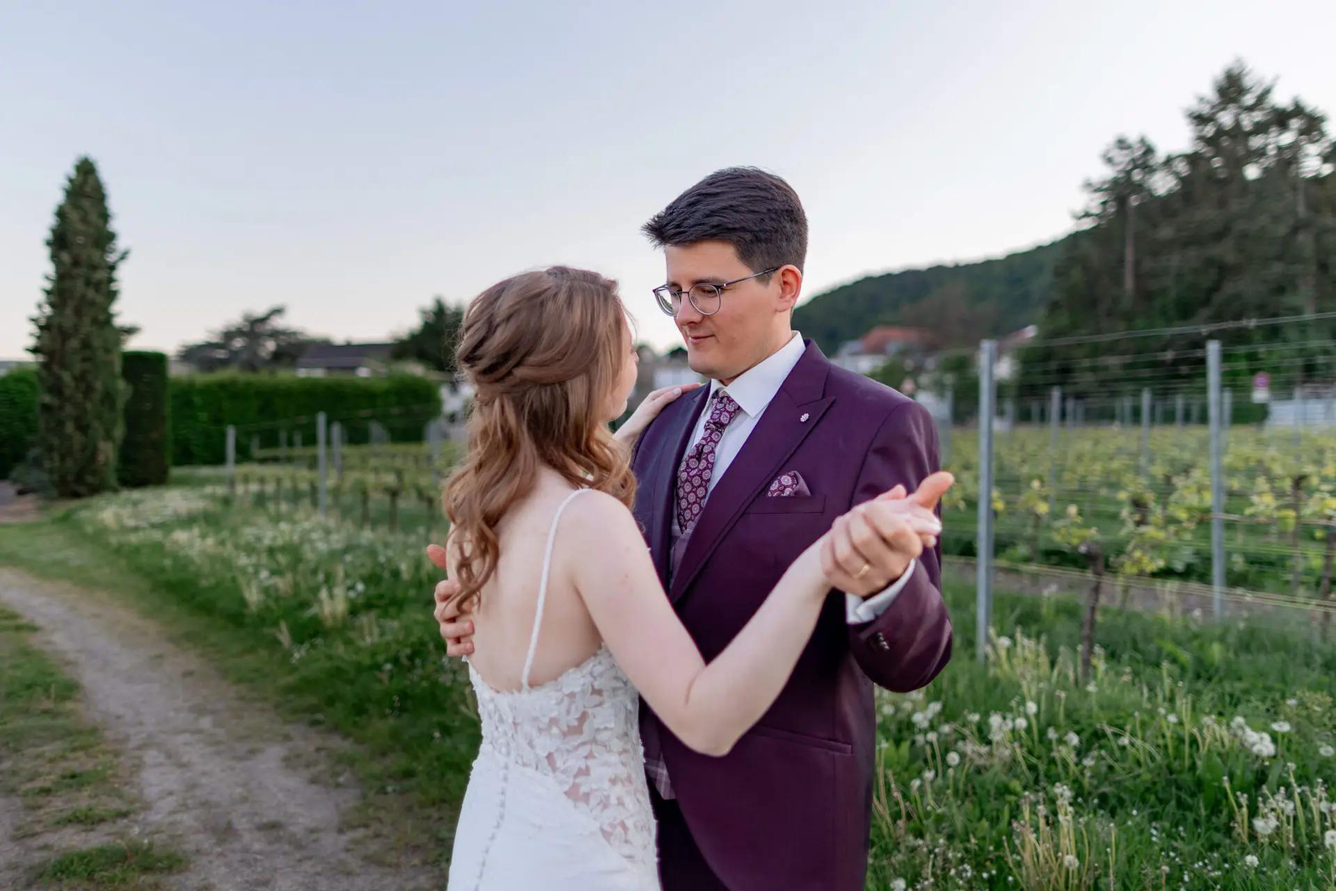 Brautpaar übt ersten Tanz in Tanzhaltung zwischen den Weinreben