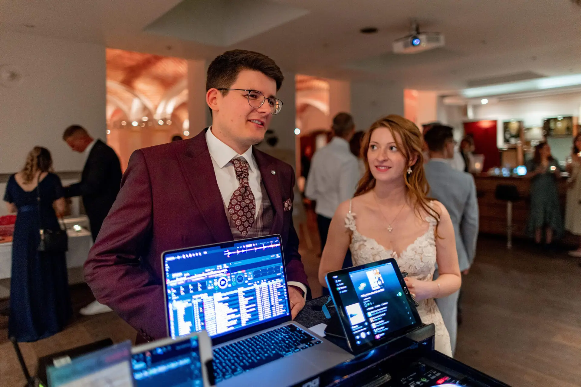 Brautpaar als DJ mit Laptops und Mischpult im stimmungsvoll beleuchteten Festsaal