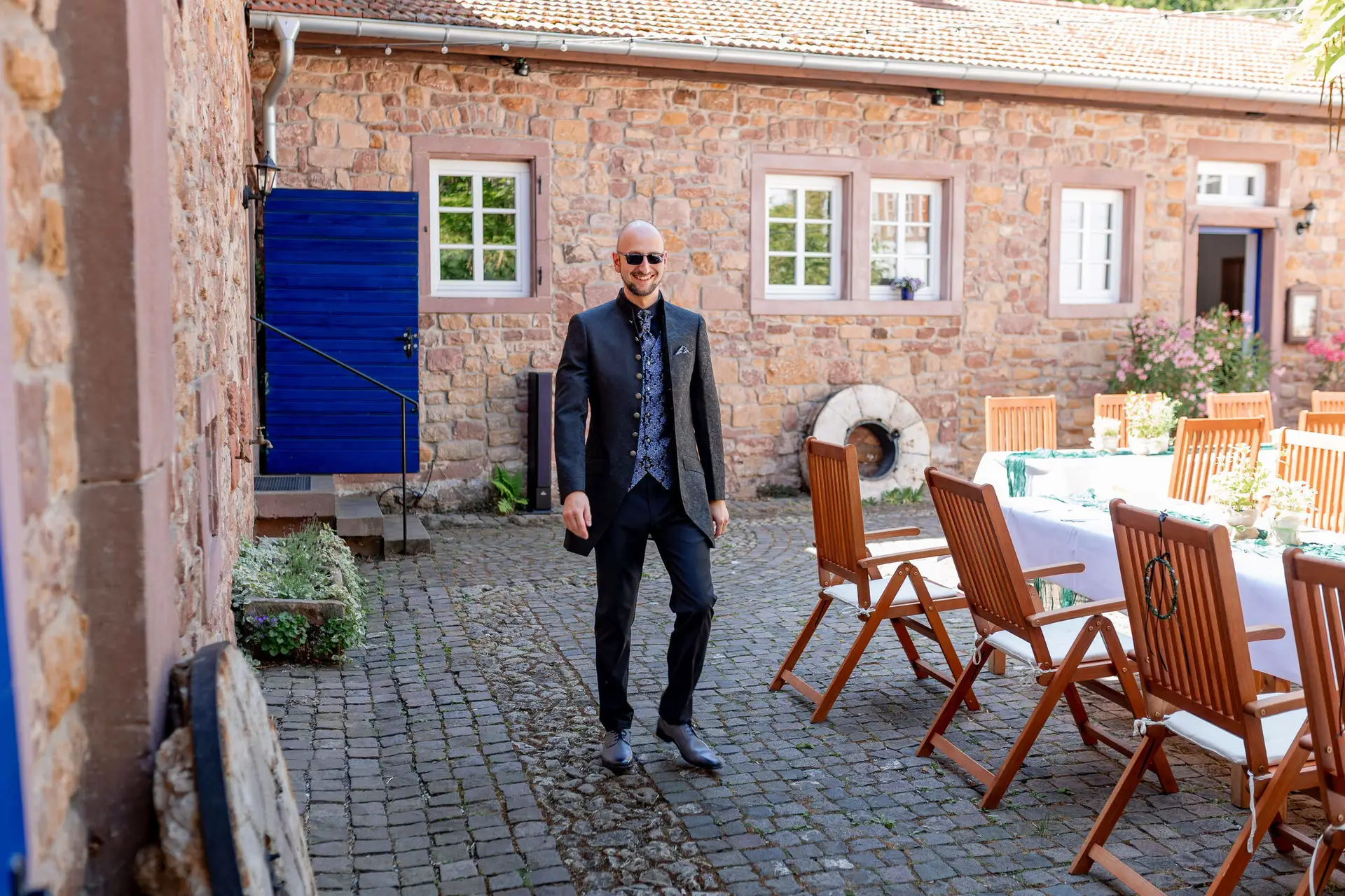 Bräutigam steht am Innenhof der Felsenmühle