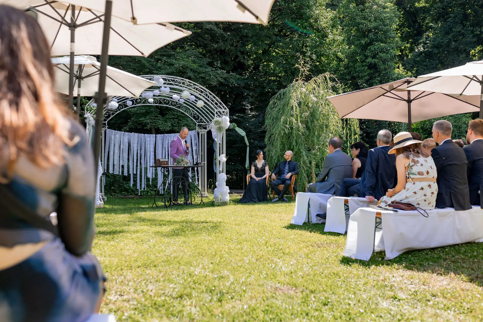 Brautpaar küsst sich unter dem Traubogen