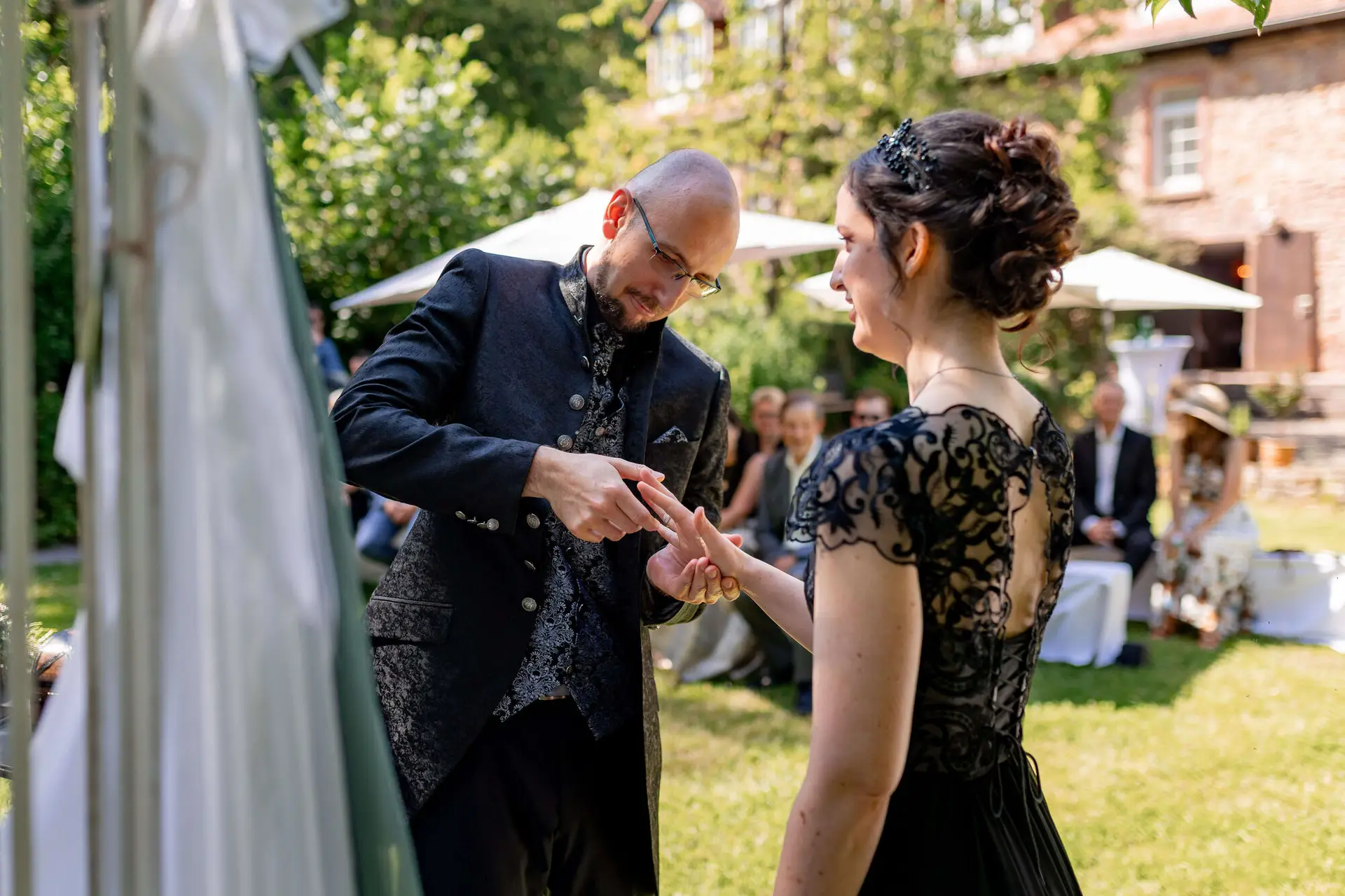 Brautpaar steht vor der Steinmauer der Felsenmühle
