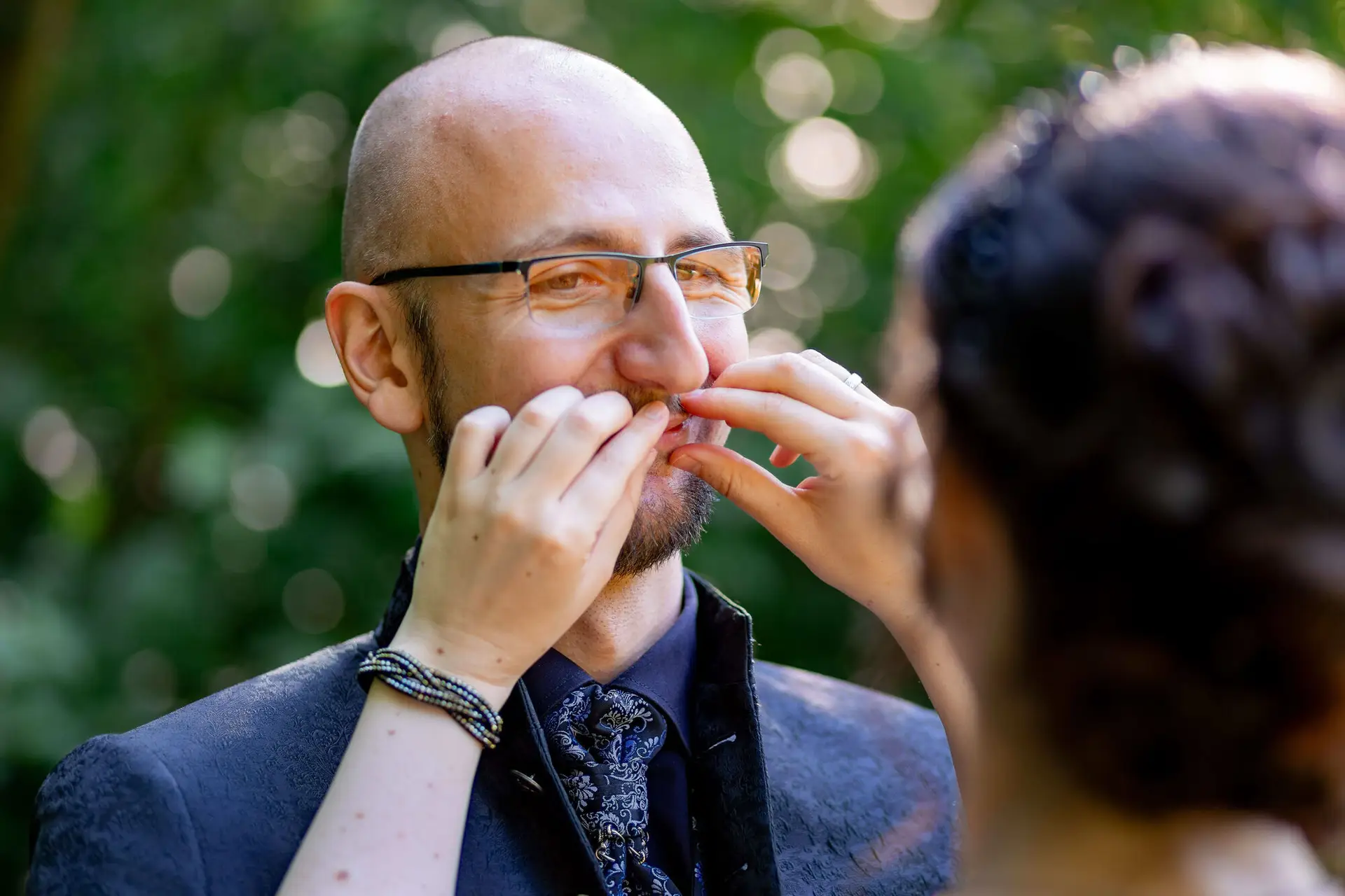 Brautpaar umarmt sich unter Efeuranken