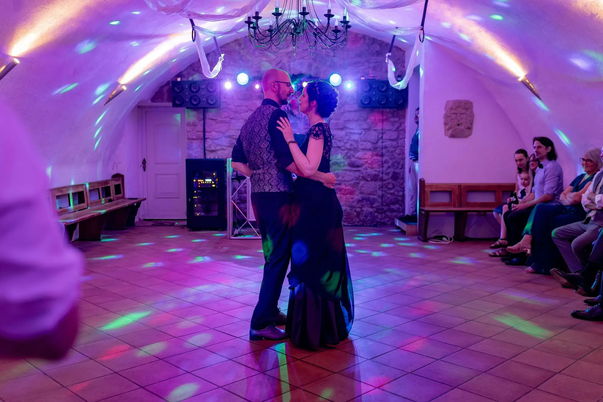 Lächelndes Brautpaar unter buntem Licht