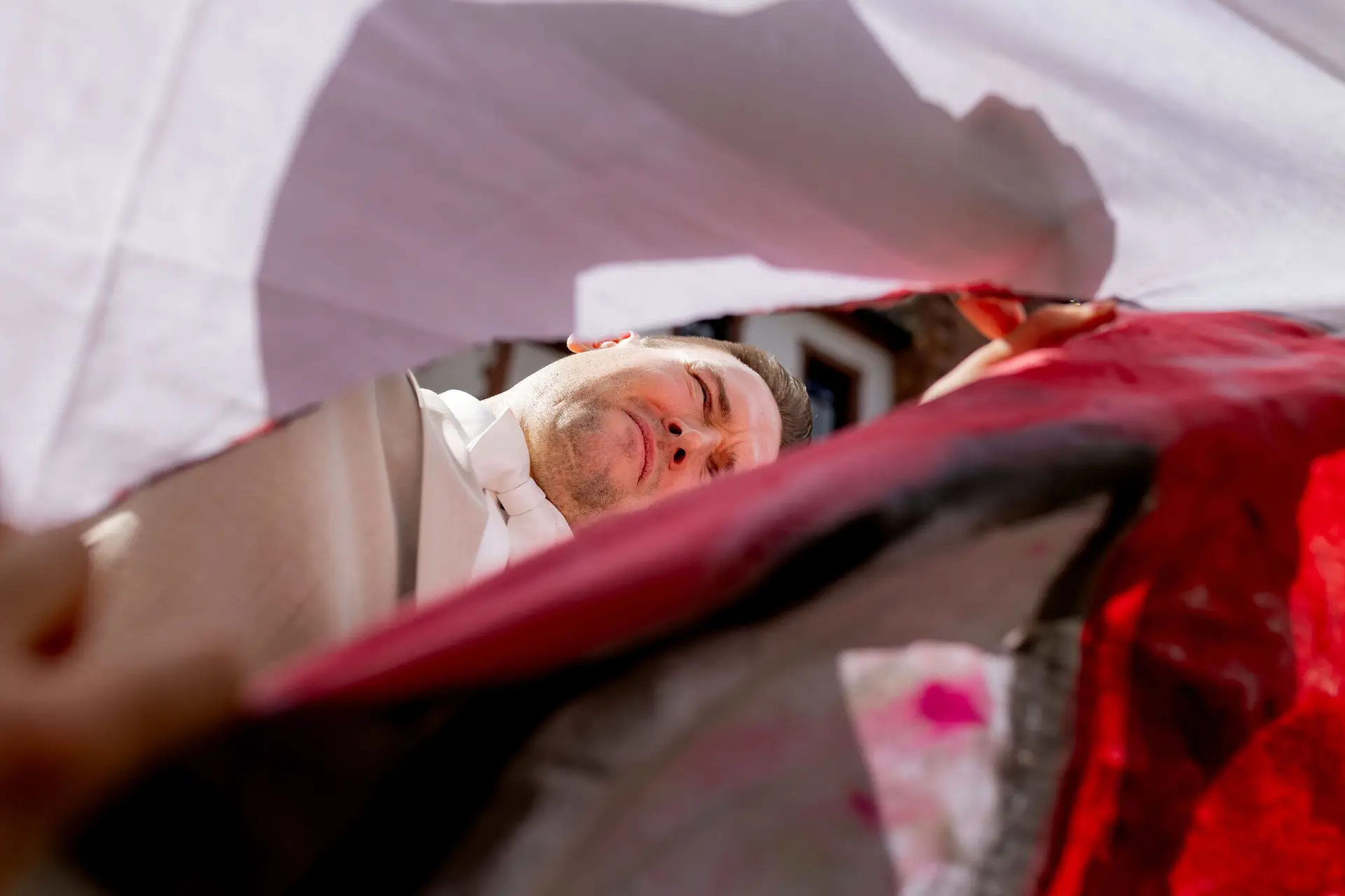 Bräutigam schneidet konzentriert das Herz aus dem Bettlaken