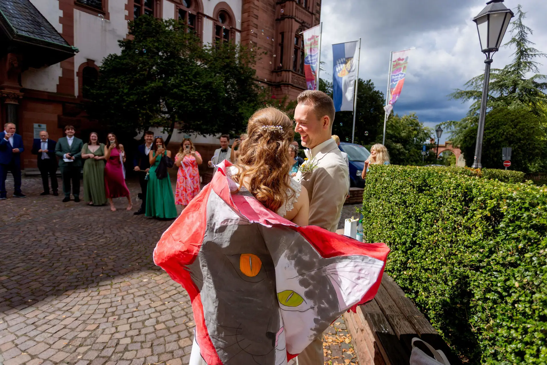 Brautpaar umarmt sich nach dem Herz-Ausschneiden vor dem Standesamt