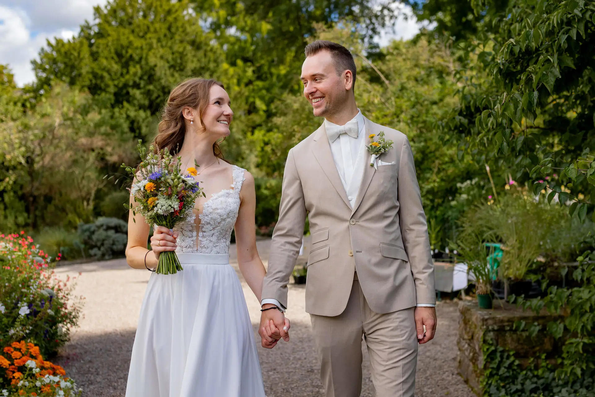 Brautpaar spaziert Hand in Hand durch den Hermannshof Weinheim