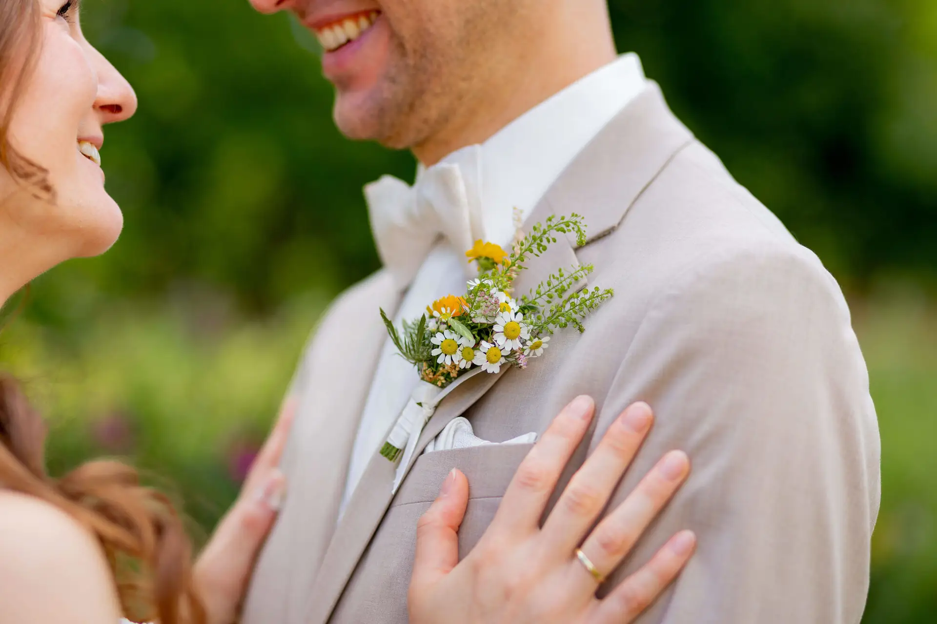 Nahaufnahme der Boutonnière mit Wildblumen am Revers des Bräutigams