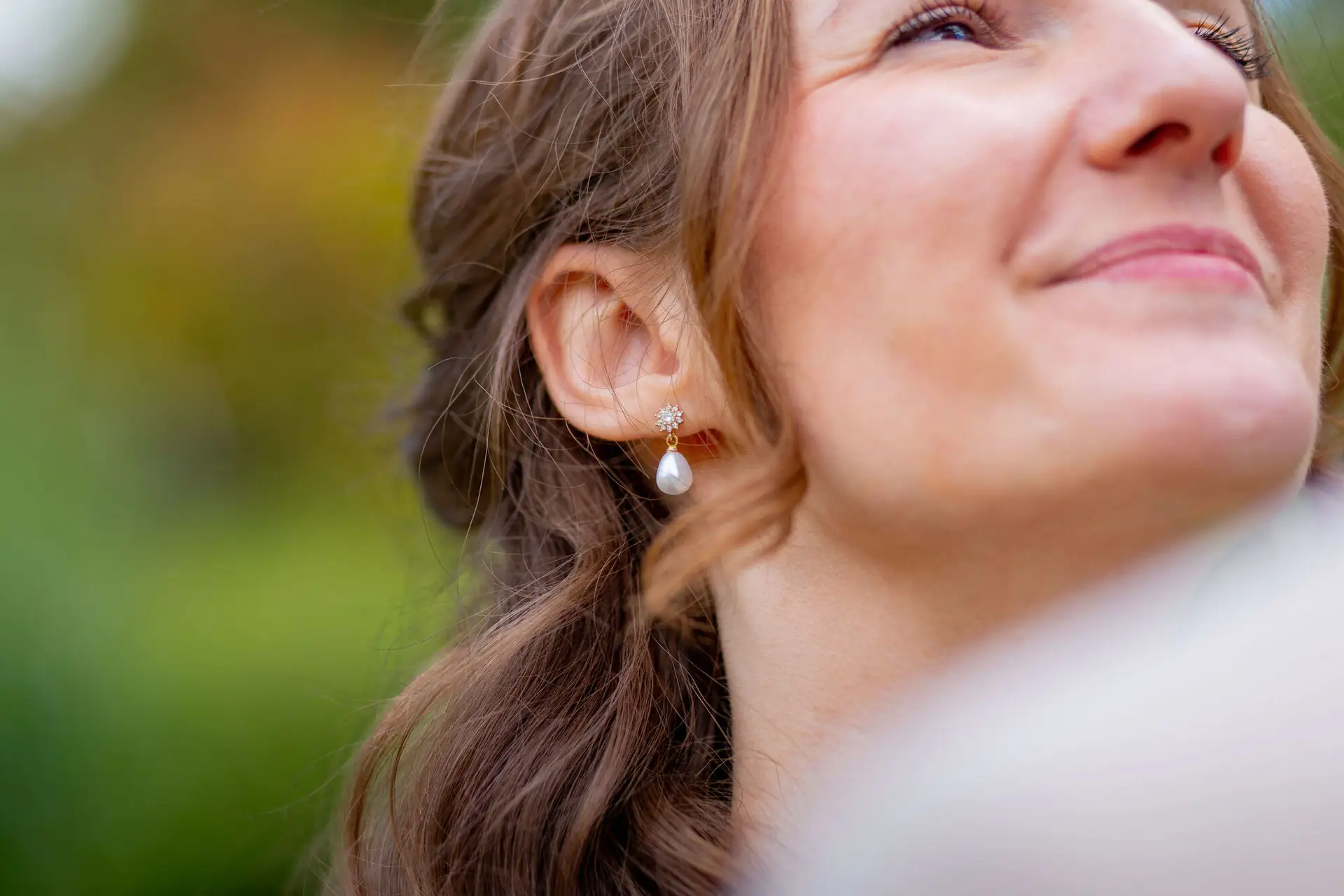 Nahaufnahme der Perlenohrringe der Braut im Sonnenlicht
