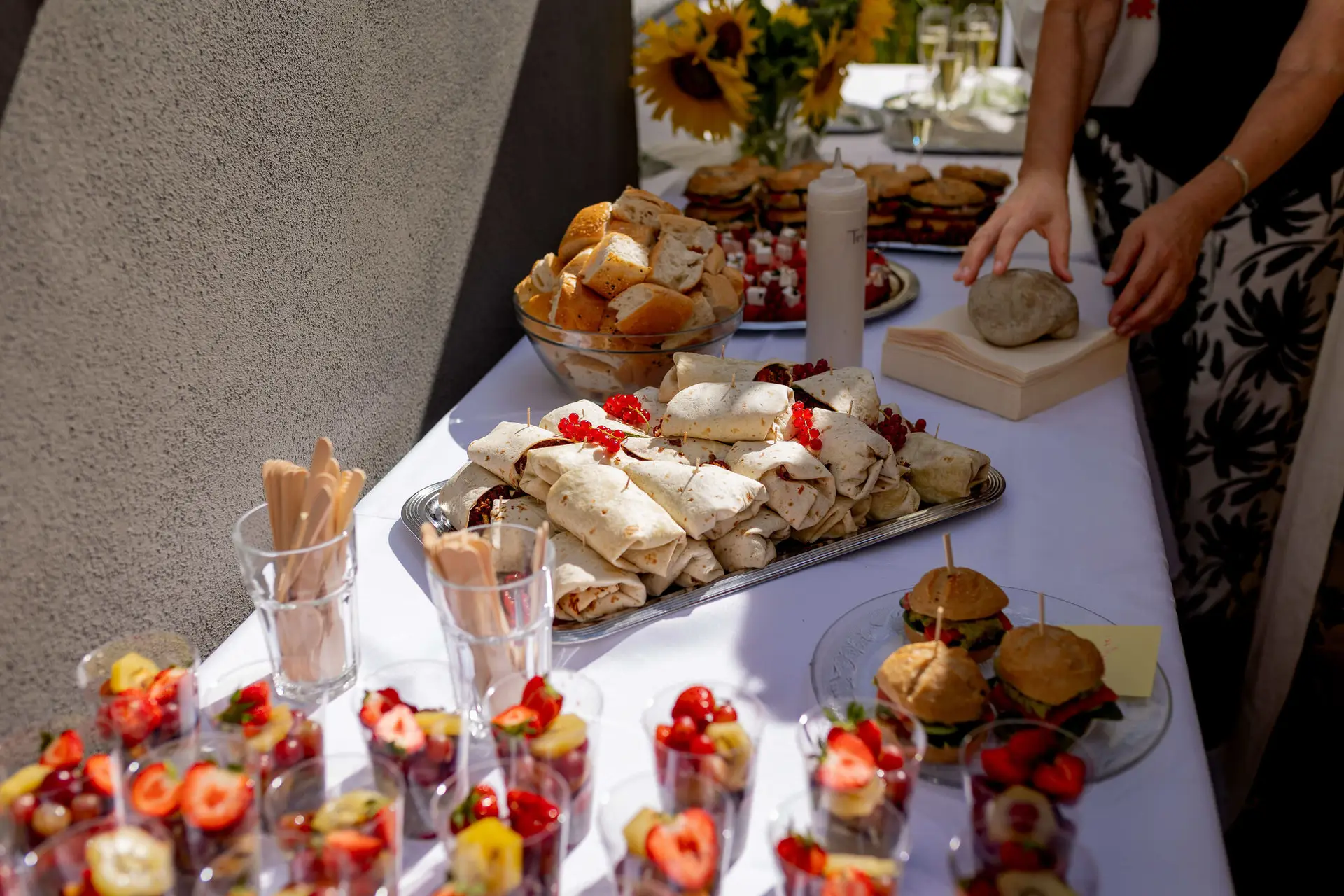 Gäste bedienen sich am Fingerfood-Buffet mit Sonnenblumen