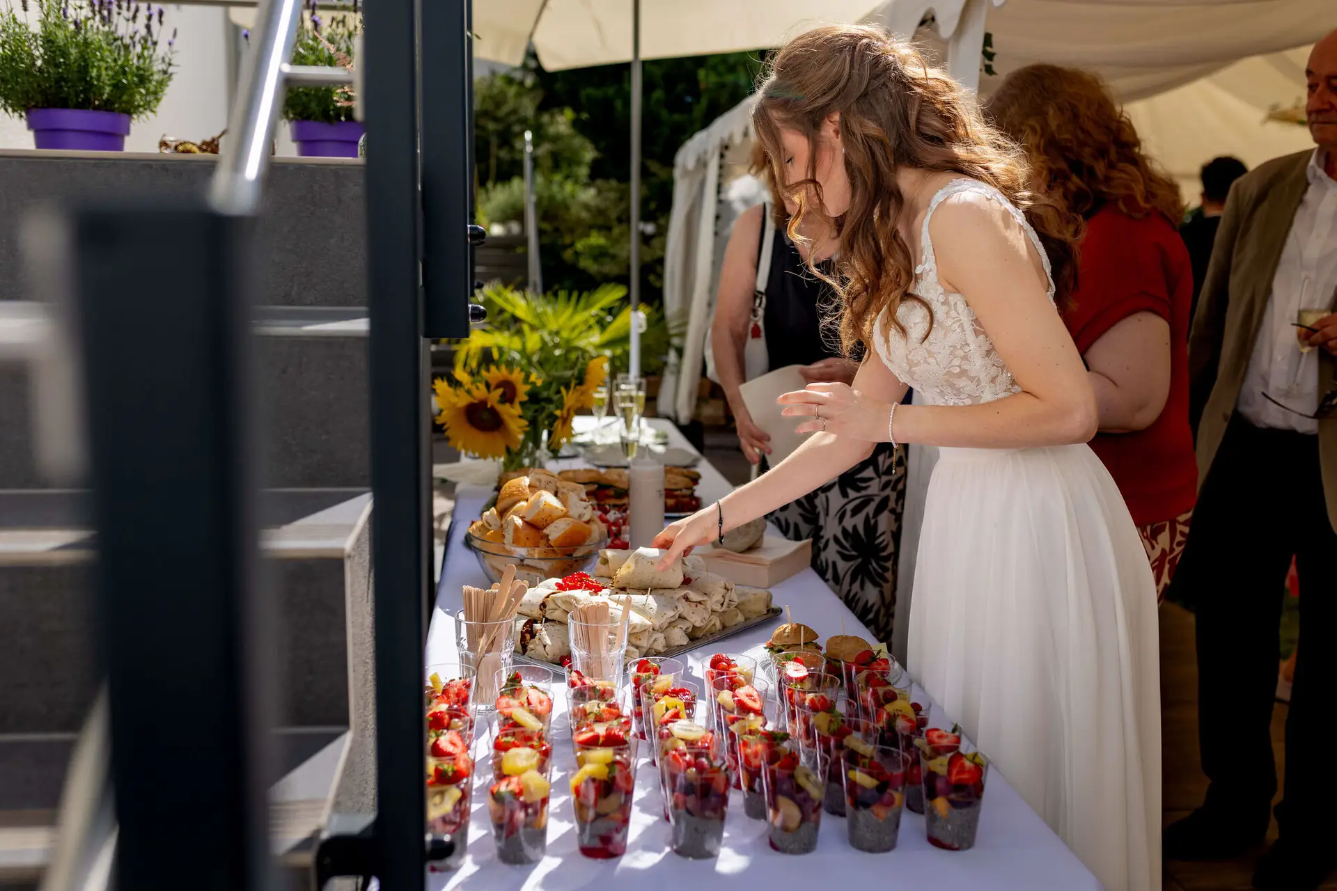 Braut bedient sich am Fingerfood-Buffet im Garten
