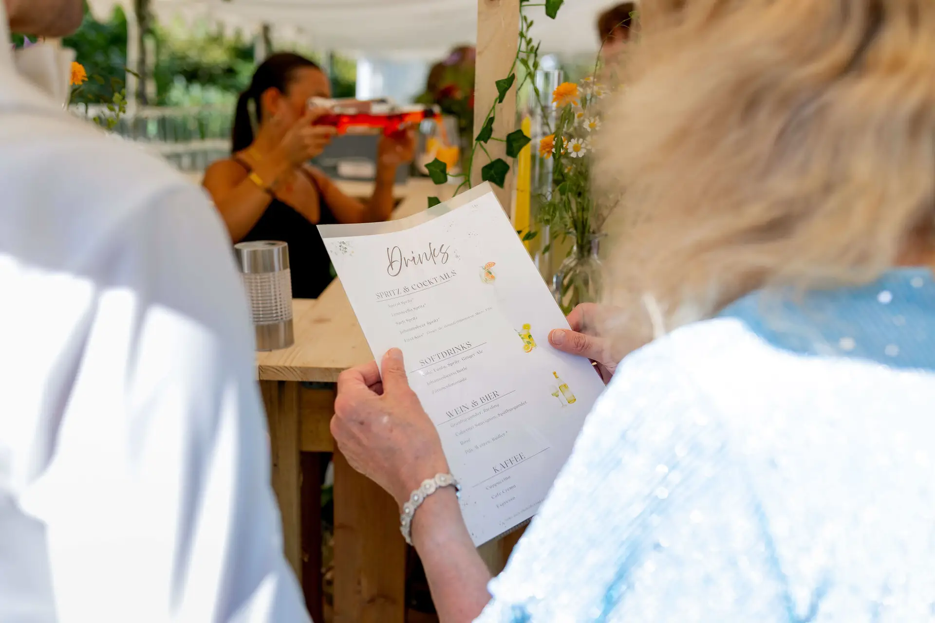 Gästin liest die Getränkekarte an der Hochzeitsbar
