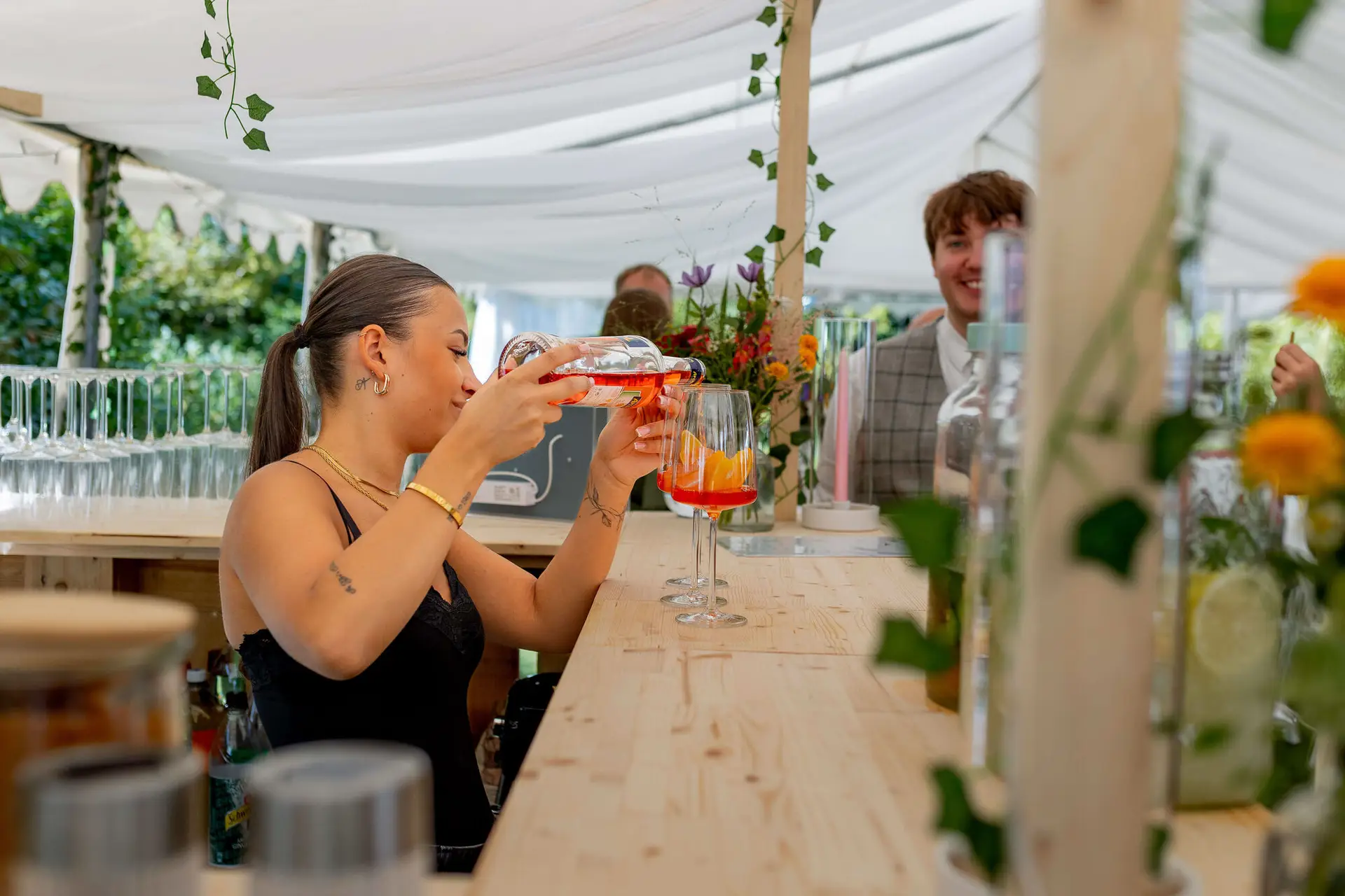 Barkeeperin mixt Aperol Spritz an der Hochzeitsbar