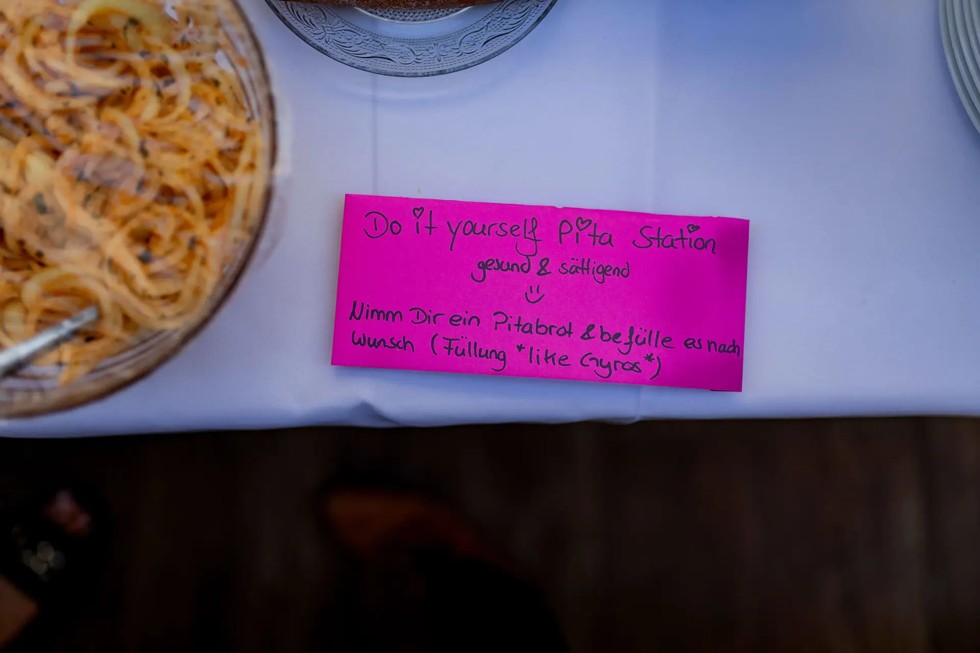 Pinkes Schild mit Aufschrift Do it yourself Pita Station am Buffet