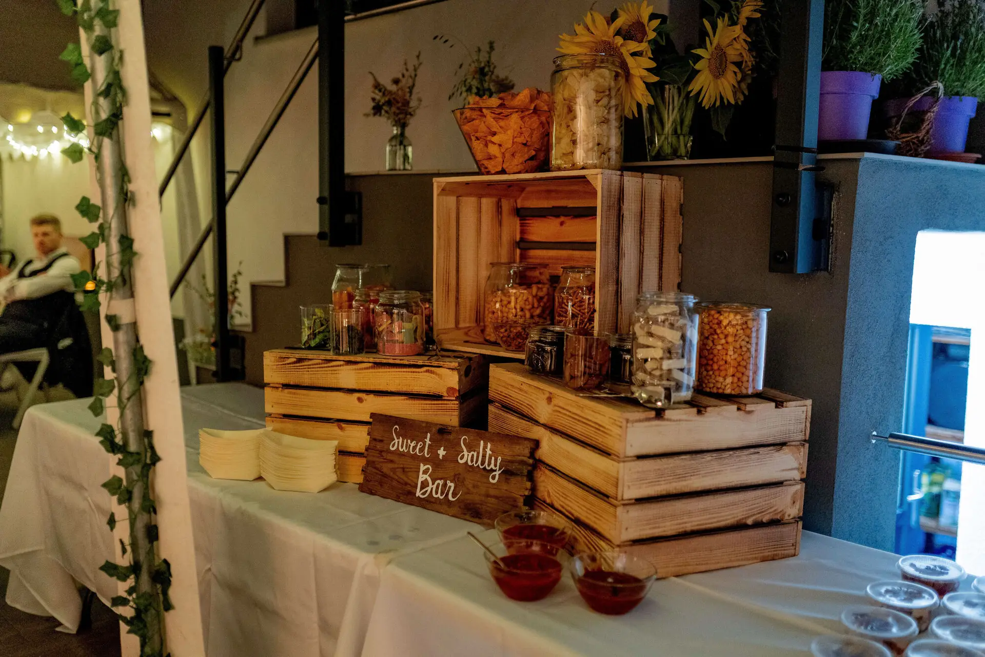 Sweet and Salty Bar mit Snacks in Holzkisten und Sonnenblumen